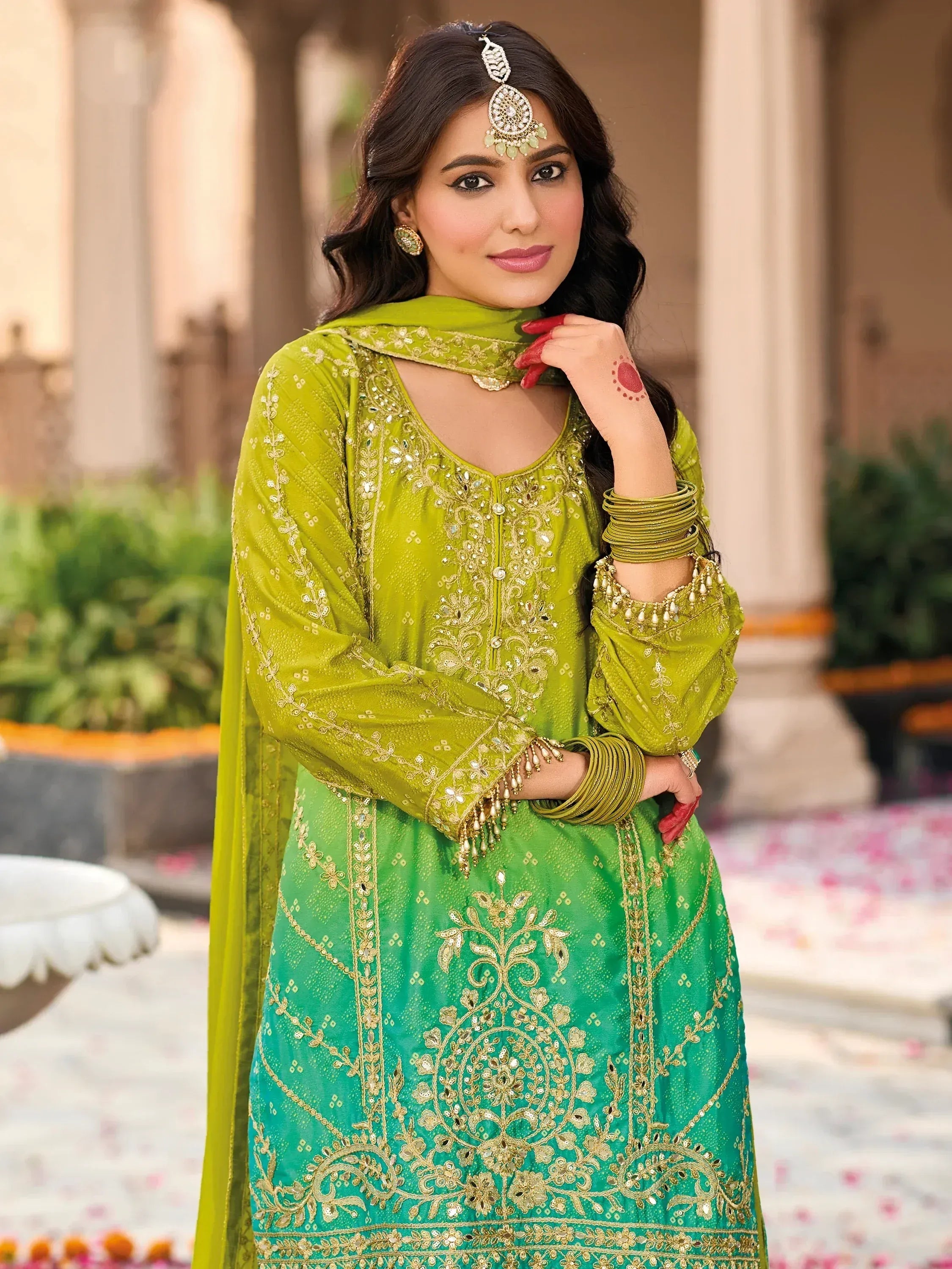 Woman in green embroidered salwar kameez with gold detailing, traditional Indian ethnic wear for festive occasions