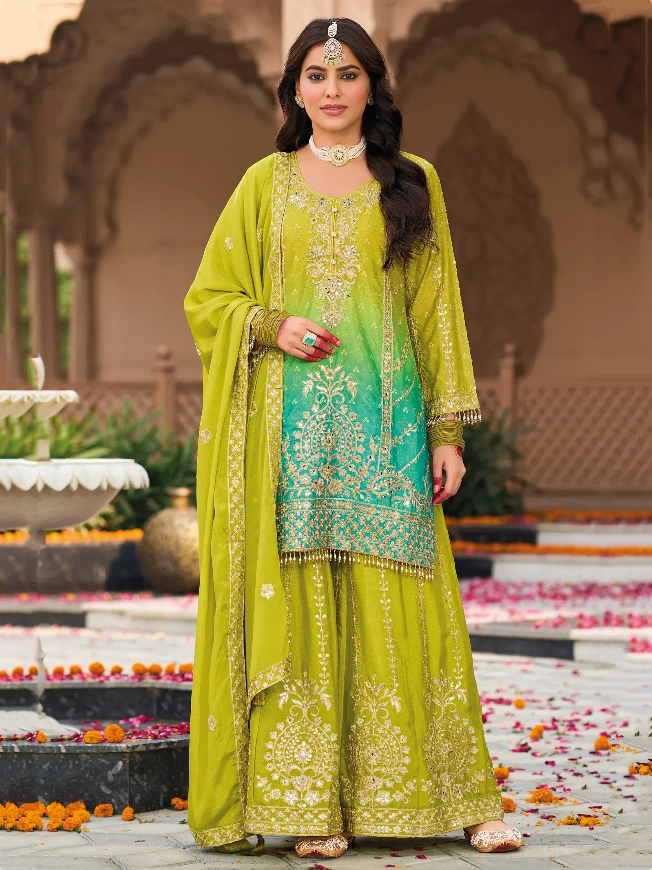 Green and turquoise embroidered salwar kameez with gold detailing, perfect for festive occasions.