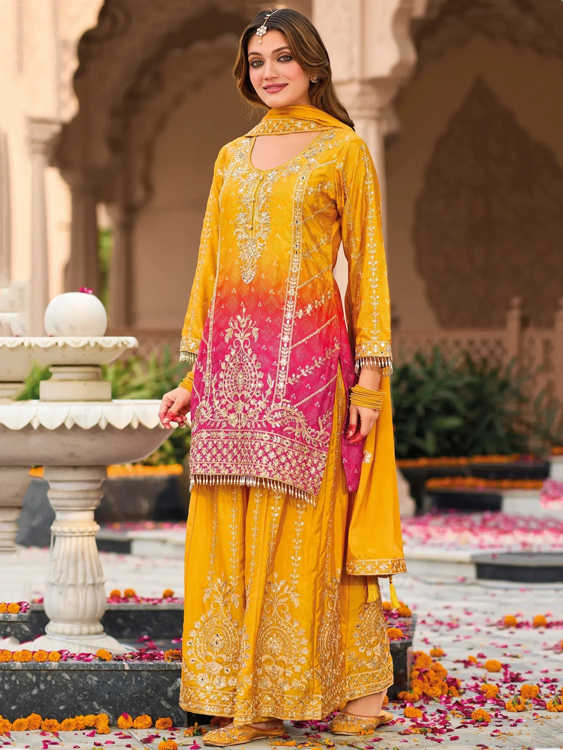 Yellow and pink embroidered salwar kameez with floral detailing, perfect for festive occasions.