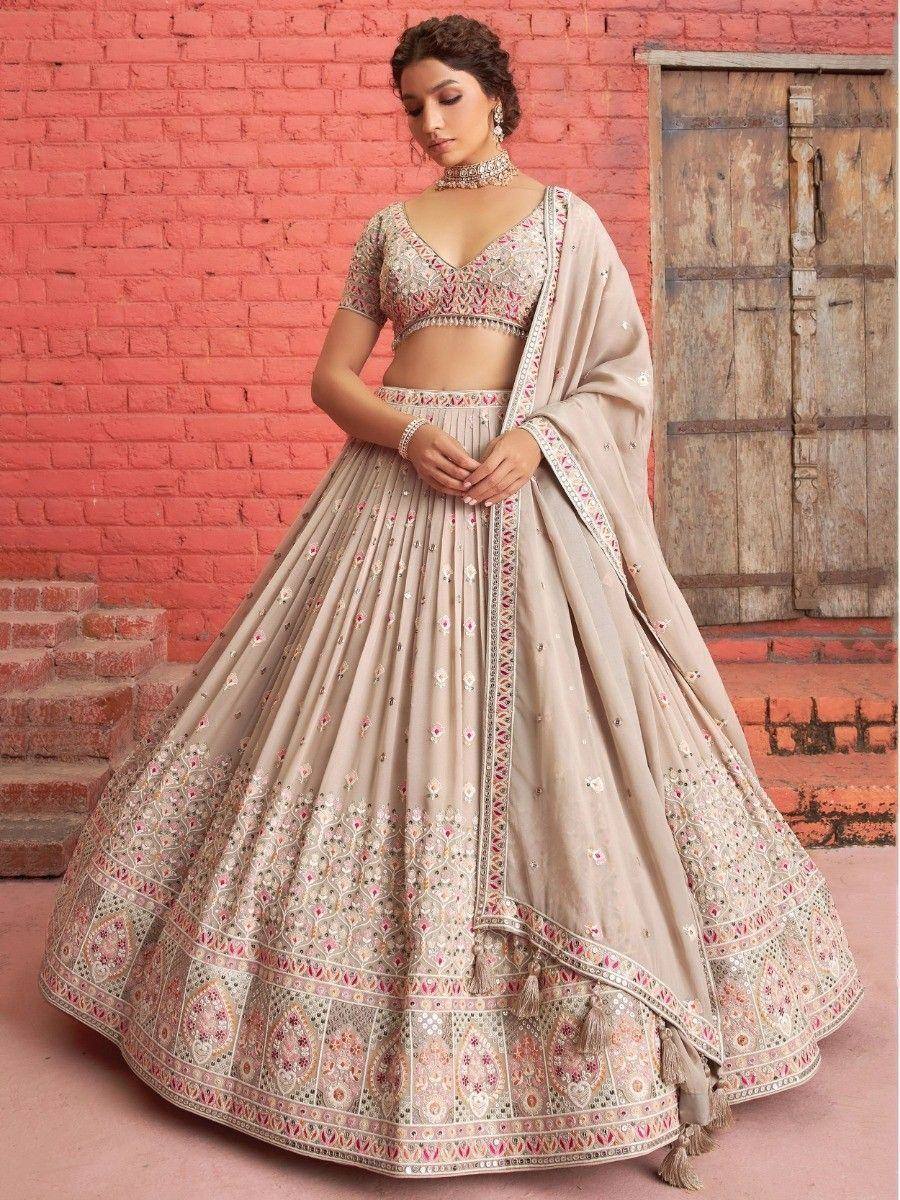 Beige embroidered lehenga choli with pink floral motifs, perfect for Indian weddings and festive occasions.