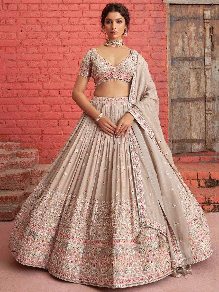 Beige embroidered lehenga choli with pink floral motifs, perfect for Indian weddings and festive occasions.