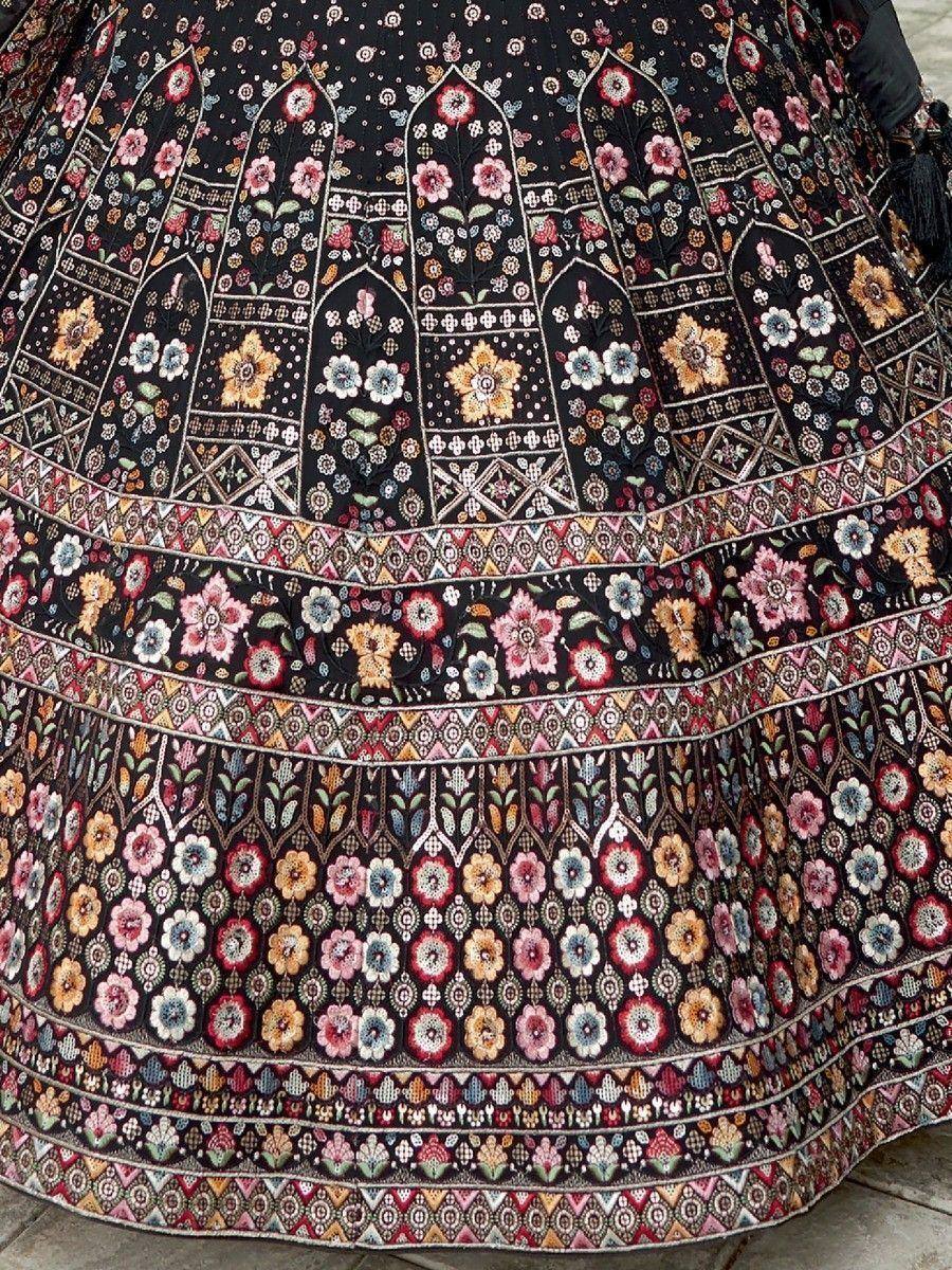 Black floral embroidered lehenga with intricate mirror work and colorful patterns, ideal for Indian ethnic wear.
