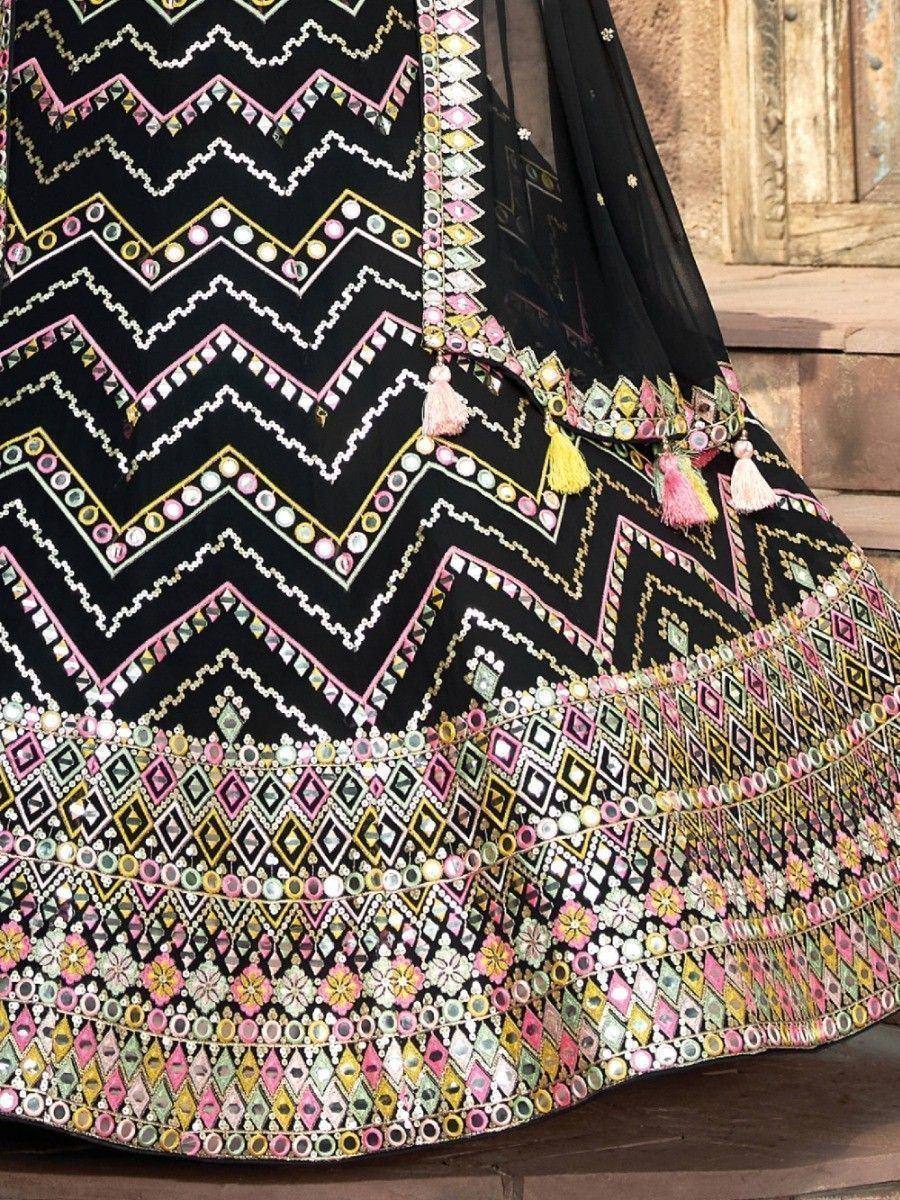 Black ethnic lehenga with colorful mirror work, geometric patterns, and tassels for festive occasions