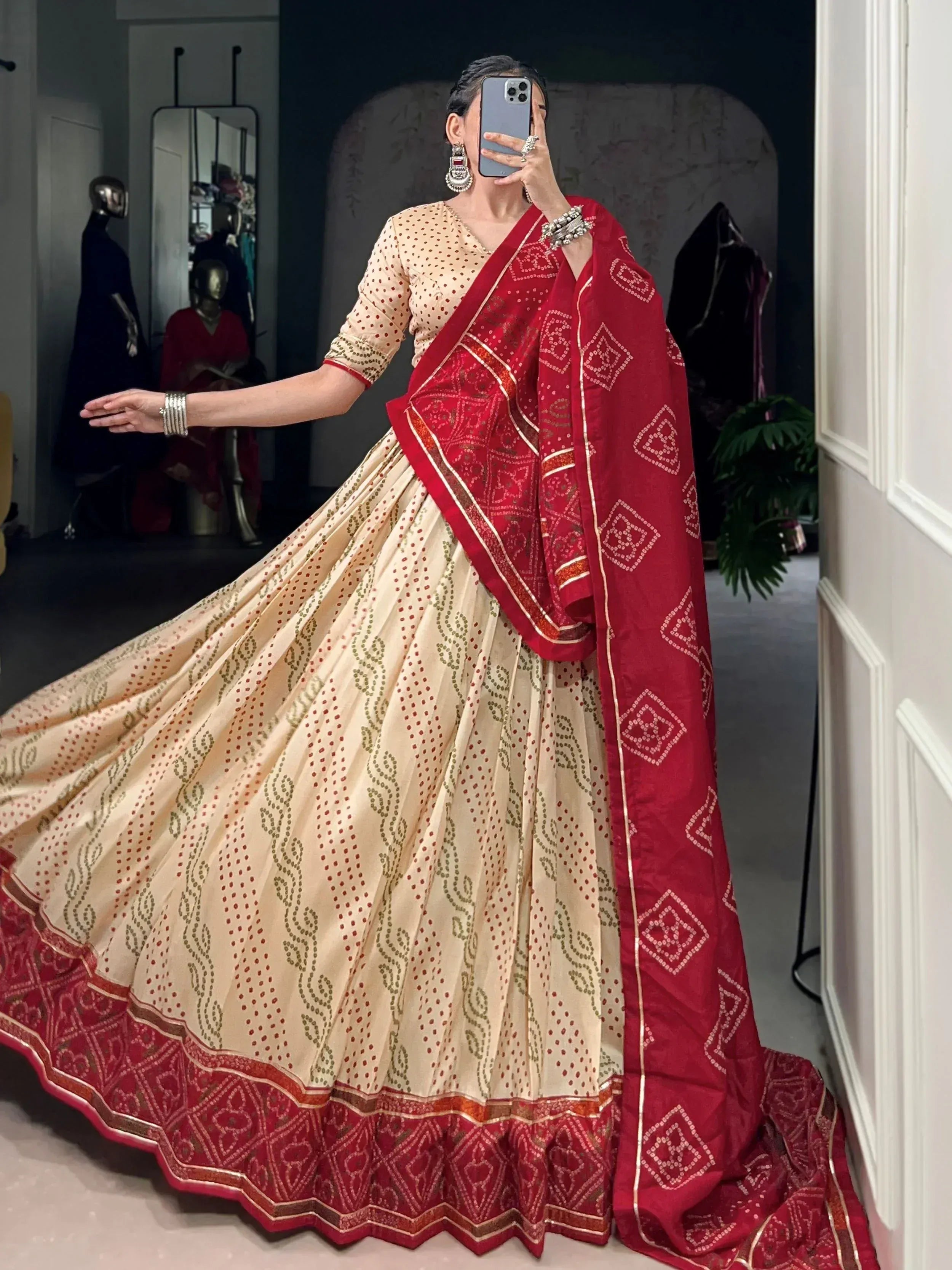 Cream and red ethnic lehenga choli with intricate patterns, perfect for Indian weddings and festive occasions.