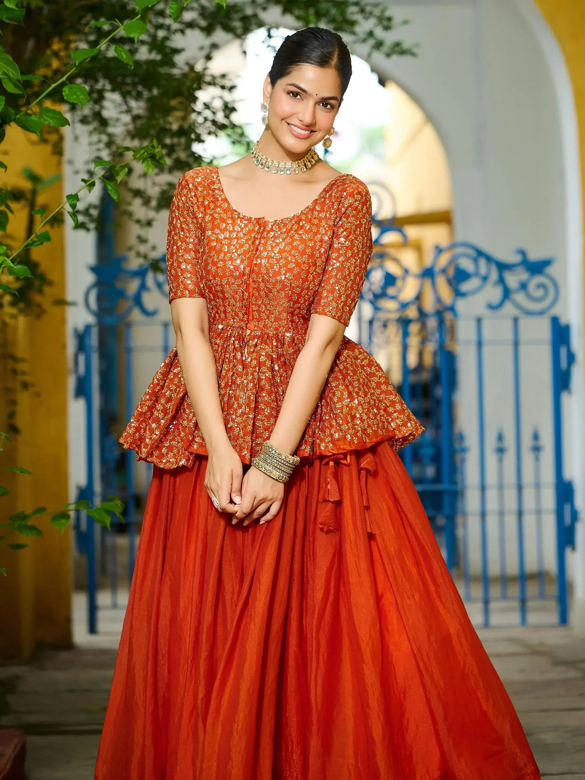 Orange embroidered lehenga choli with peplum top and flared skirt, perfect for Indian ethnic occasions