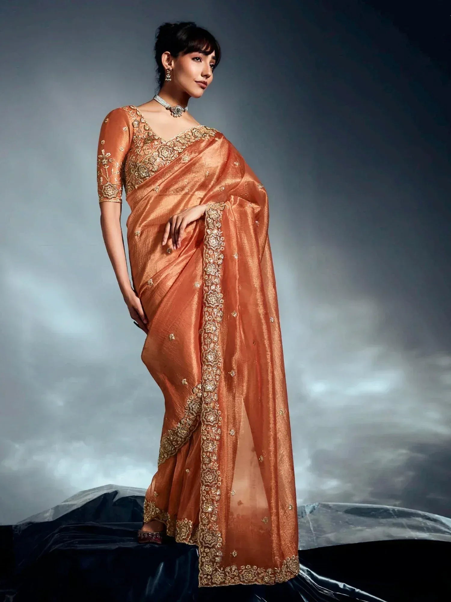 Elegant orange saree with gold embroidery, perfect for Indian ethnic wear and festive occasions.