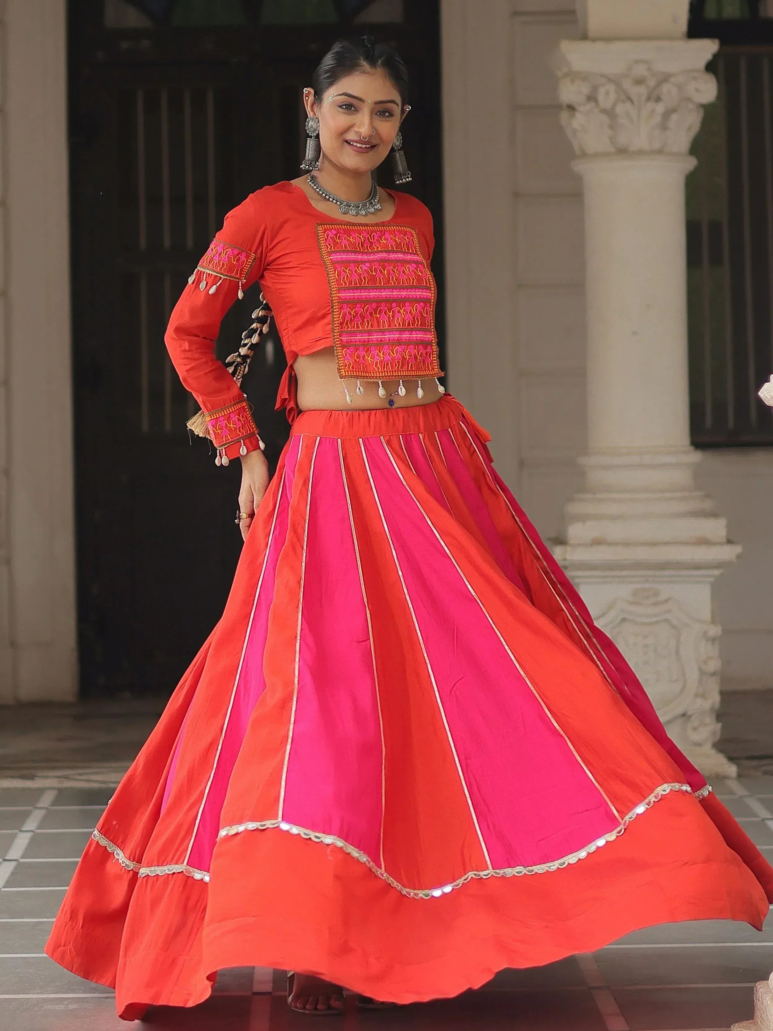 Vibrant red and pink embroidered lehenga choli with traditional Indian design