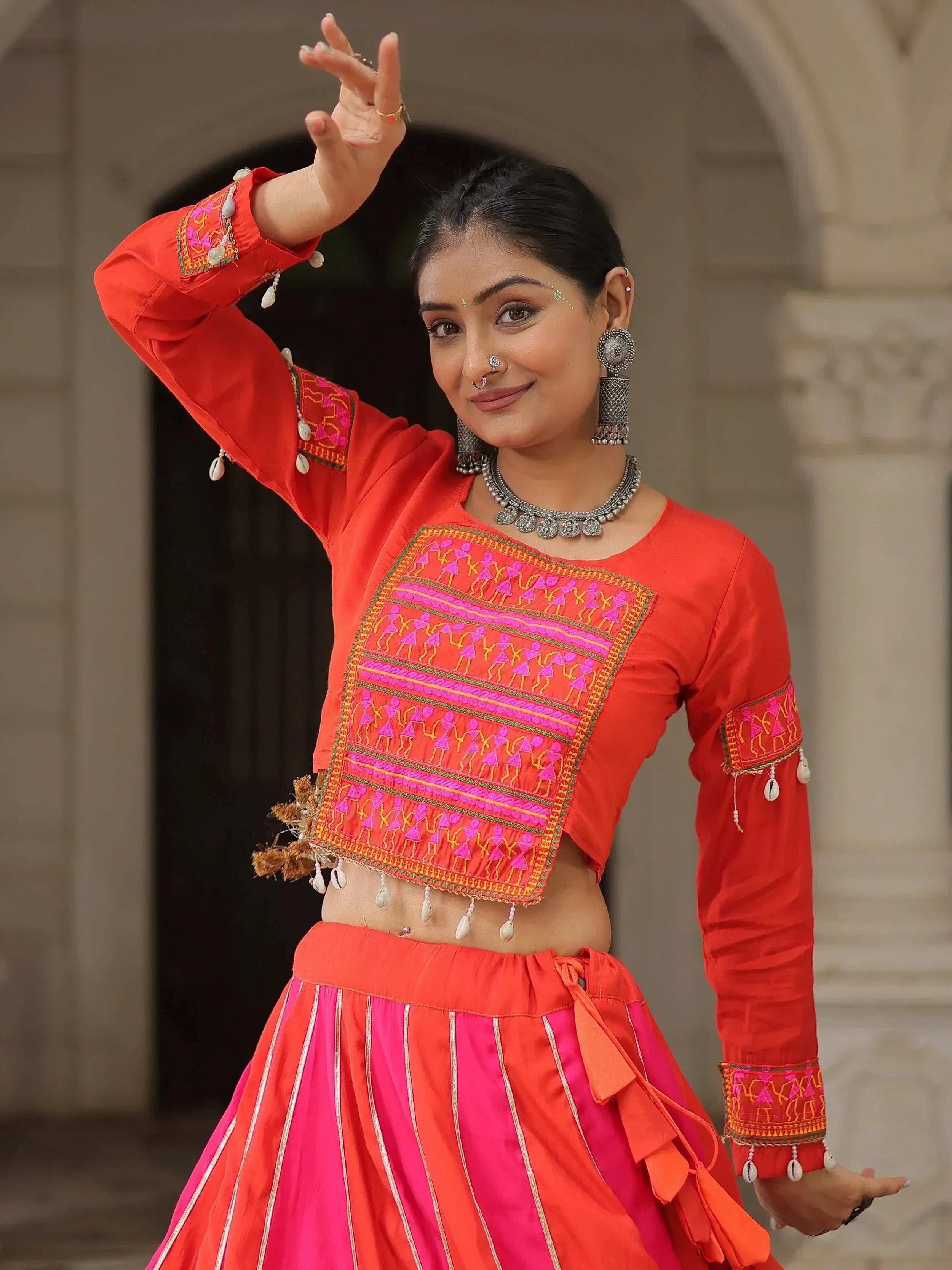 Vibrant red and pink ethnic wear with intricate embroidery and mirror work, perfect for festive occasions.