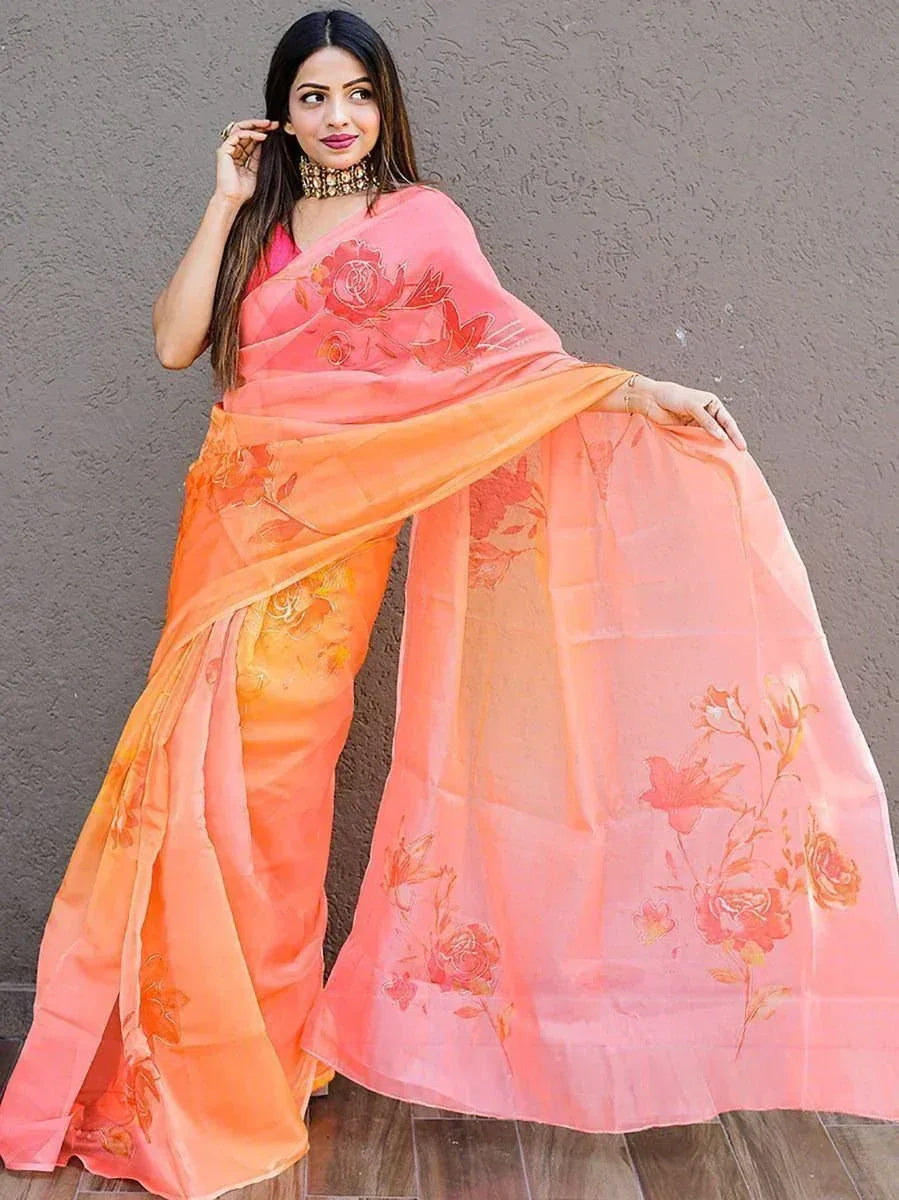 Woman in peach and orange floral printed saree with designer blouse, ethnic wear for festive occasions