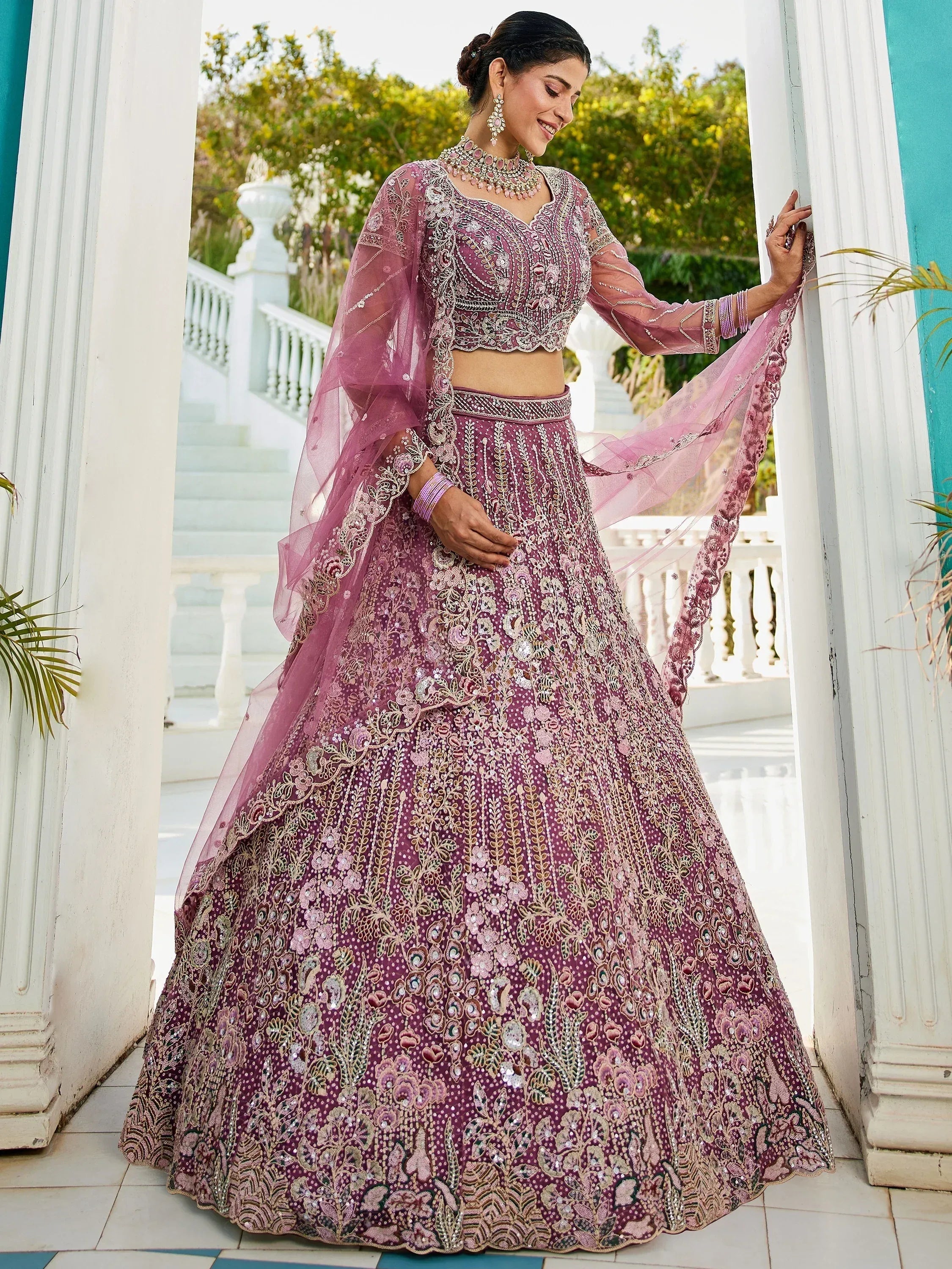 Elegant purple embroidered lehenga choli with sheer dupatta, perfect for Indian weddings and festive occasions.