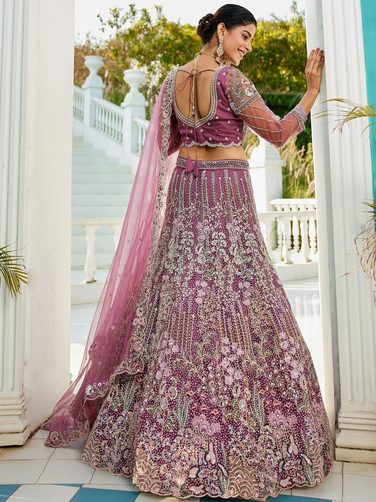 Elegant purple lehenga choli with intricate gold embroidery and sheer dupatta, perfect for Indian weddings and festive occasions.