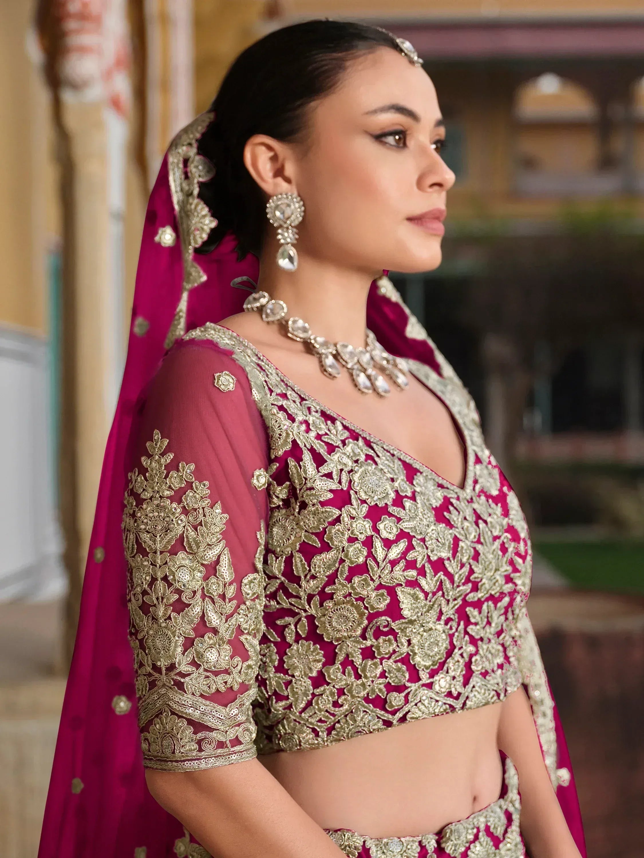 Elegant magenta lehenga choli with gold floral embroidery, perfect for Indian weddings and festive occasions.
