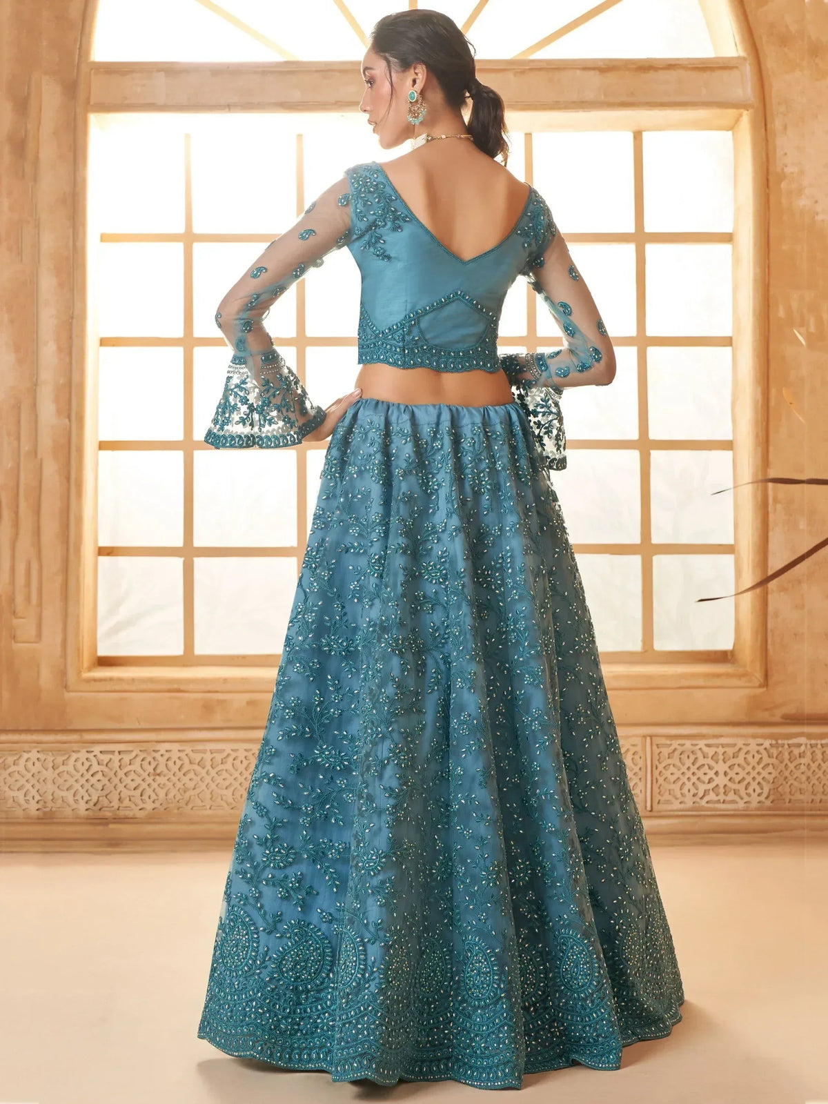 Teal blue embroidered lehenga choli with sheer bell sleeves, perfect for Indian ethnic wear occasions.