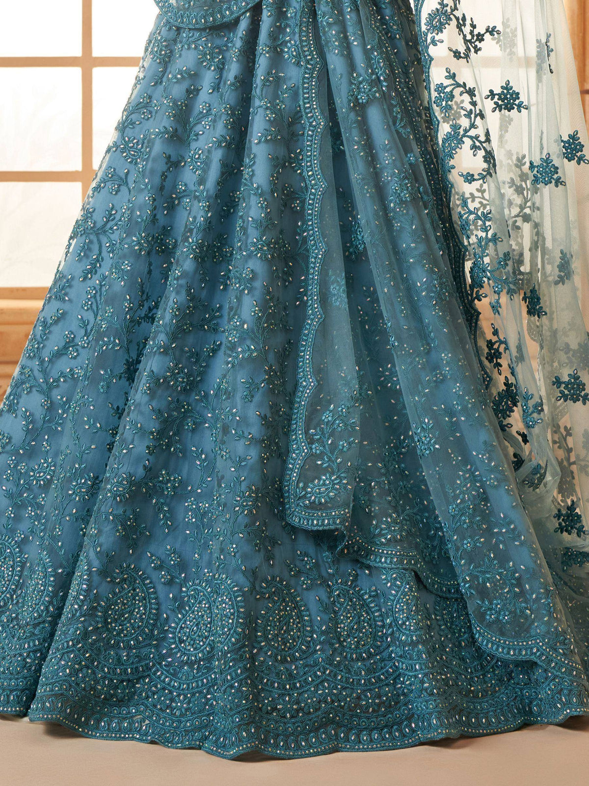 Teal blue designer lehenga with intricate floral embroidery and sequin detailing, perfect for Indian ethnic wear.