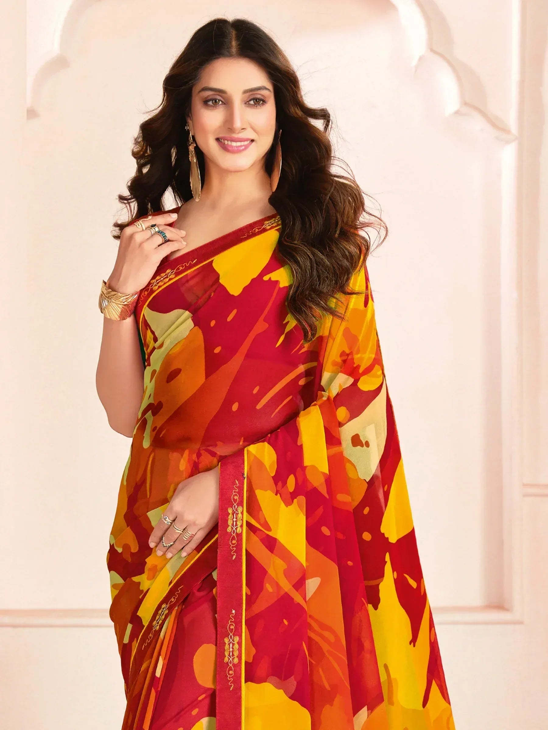 Vibrant red and yellow printed saree with gold border, styled for Indian ethnic wear occasions