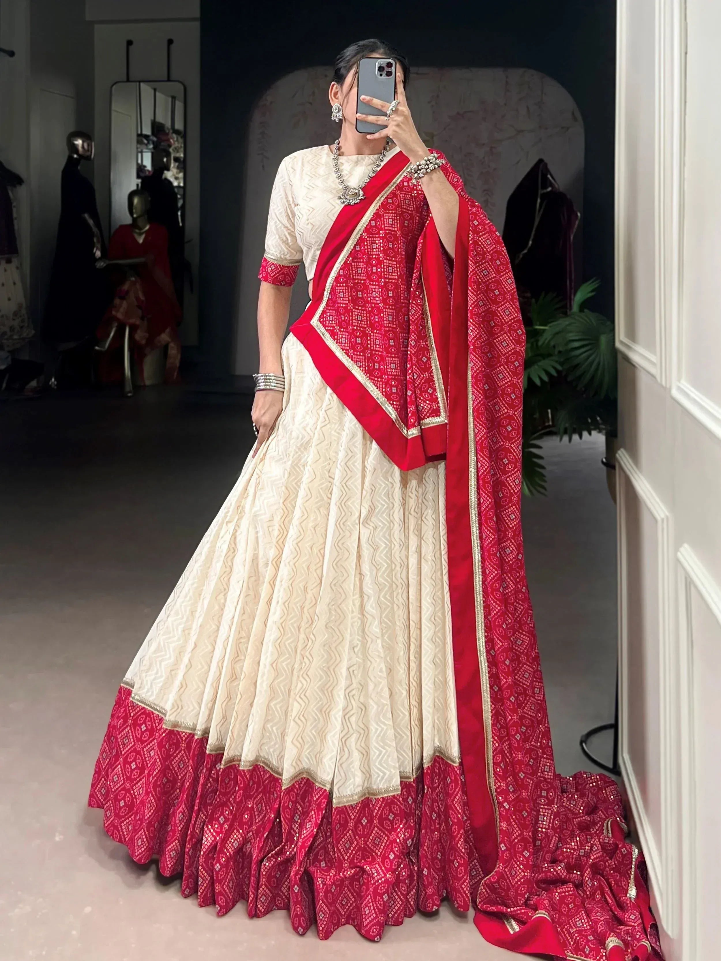 Elegant cream and red lehenga choli with intricate patterns and gold trim, perfect for Indian ethnic wear.