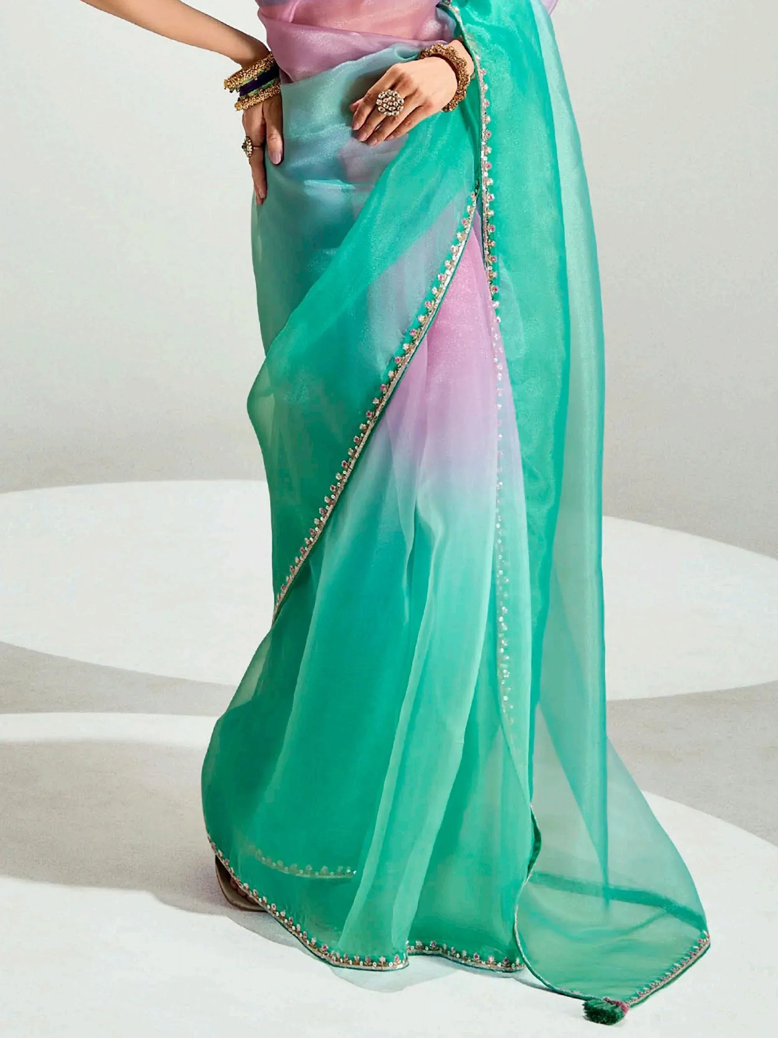 Elegant turquoise and pink saree with embroidered border, perfect for Indian ethnic wear occasions.