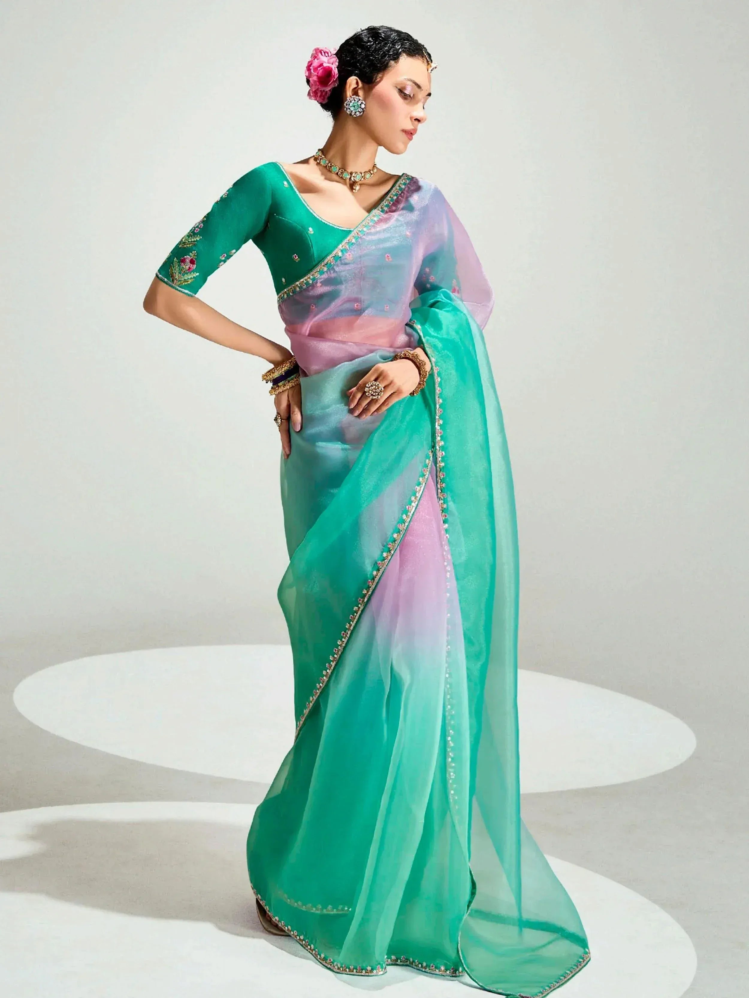 Woman in elegant green and pastel ombre saree with floral embroidery, perfect for Indian ethnic occasions.