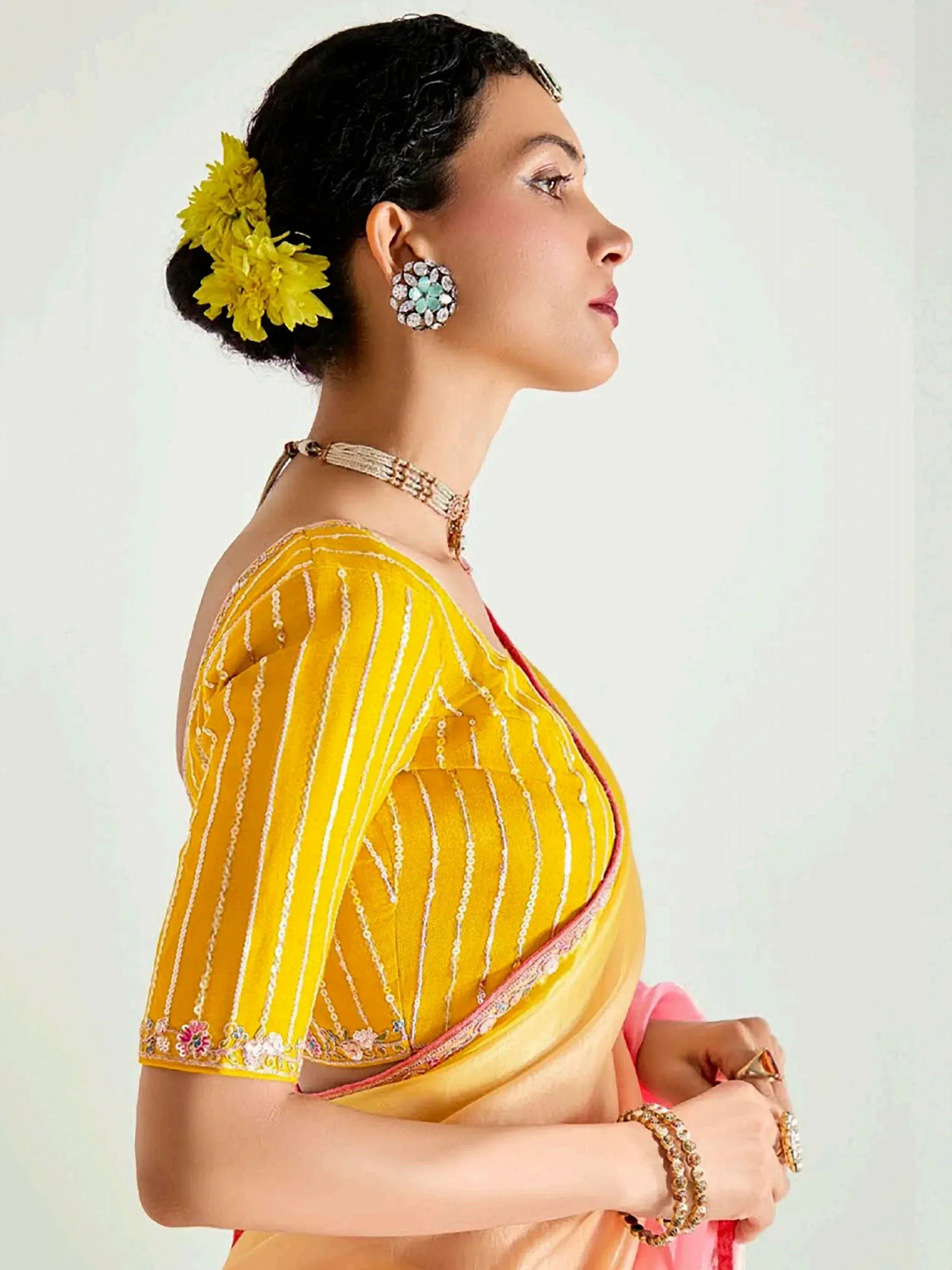 Yellow striped saree blouse with floral embroidery and traditional jewelry
