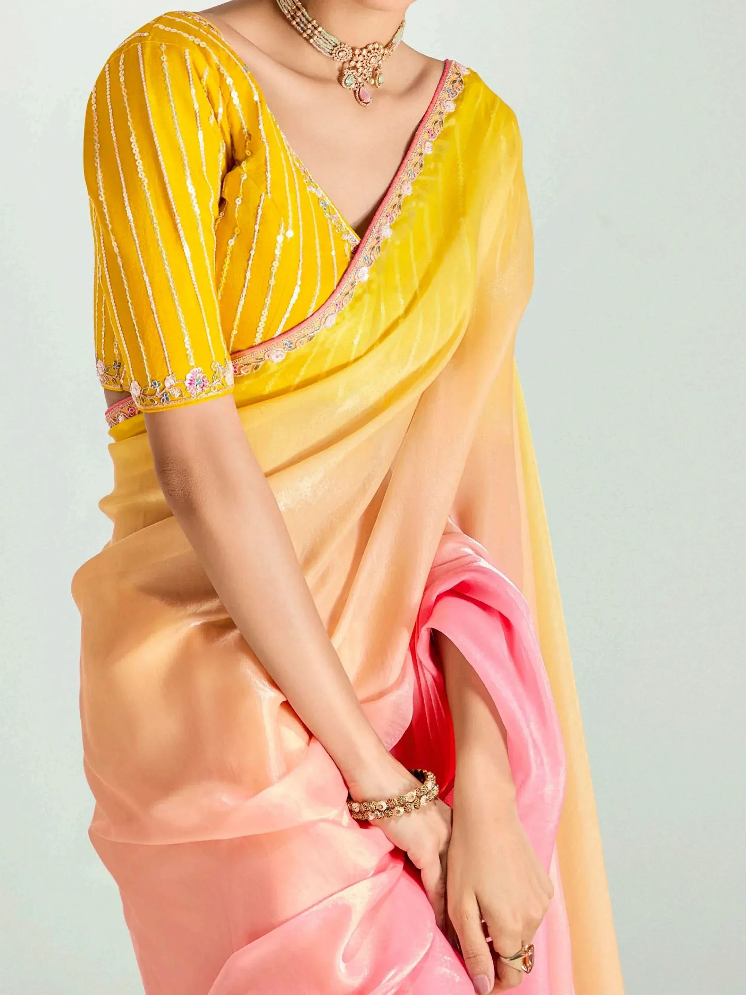 Yellow and pink designer saree with embroidered blouse and jewelry