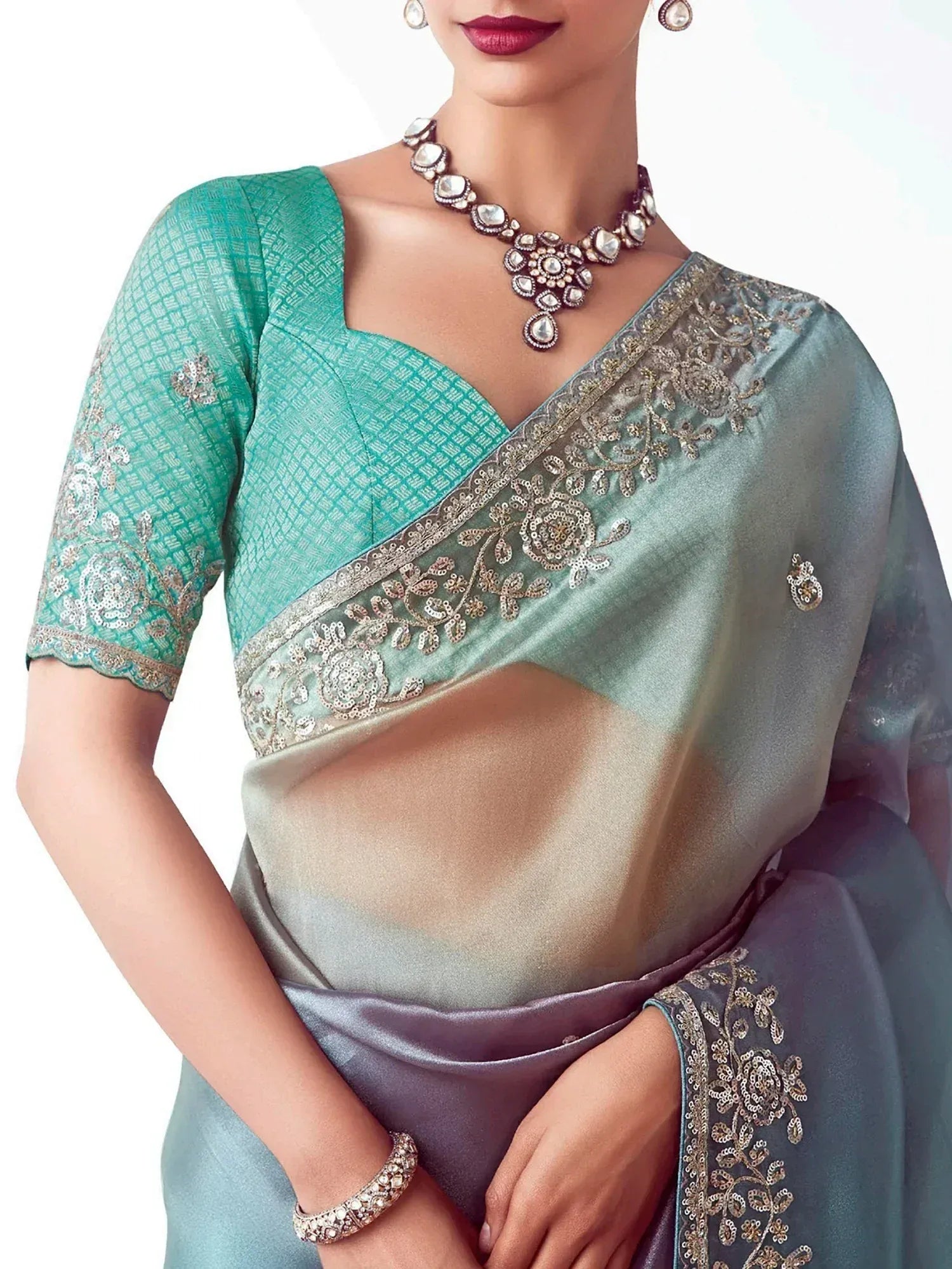 Teal embroidered saree with matching blouse, gold floral border, and traditional Indian jewelry