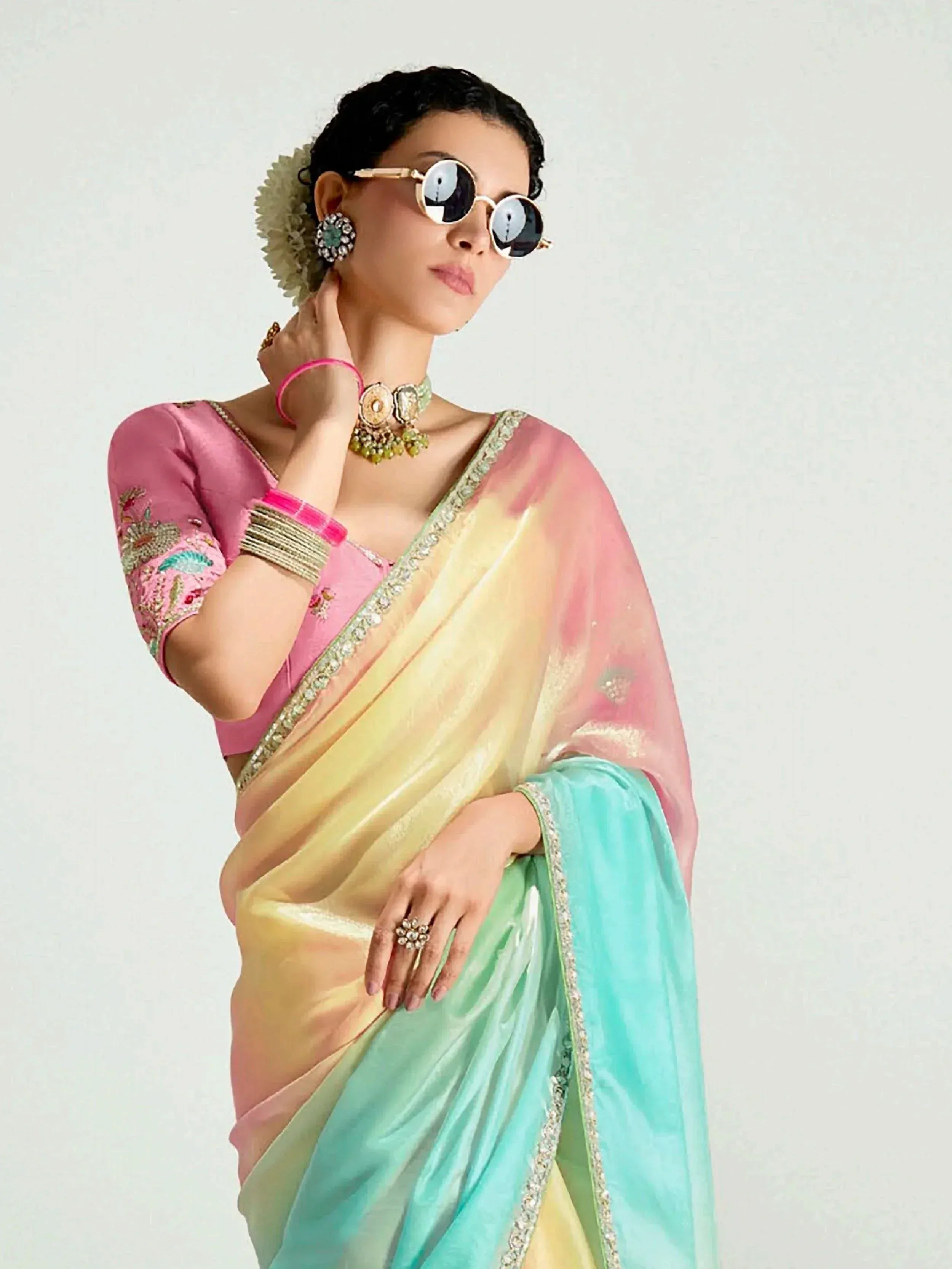 Woman in colorful ombre saree with pink blouse, floral embroidery, and statement jewelry for ethnic wear