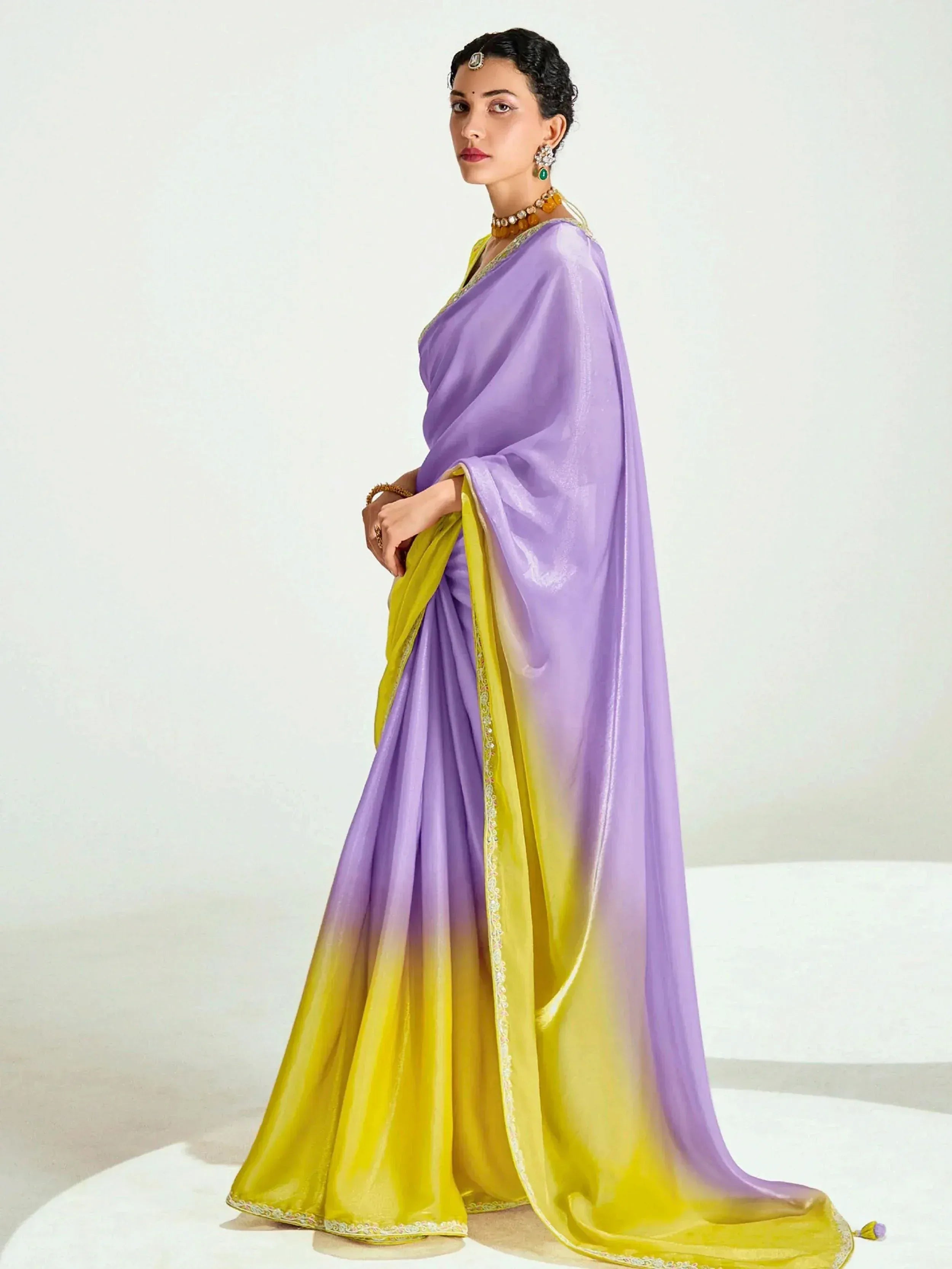 Purple and yellow ombre saree with golden embroidery, styled with traditional jewelry