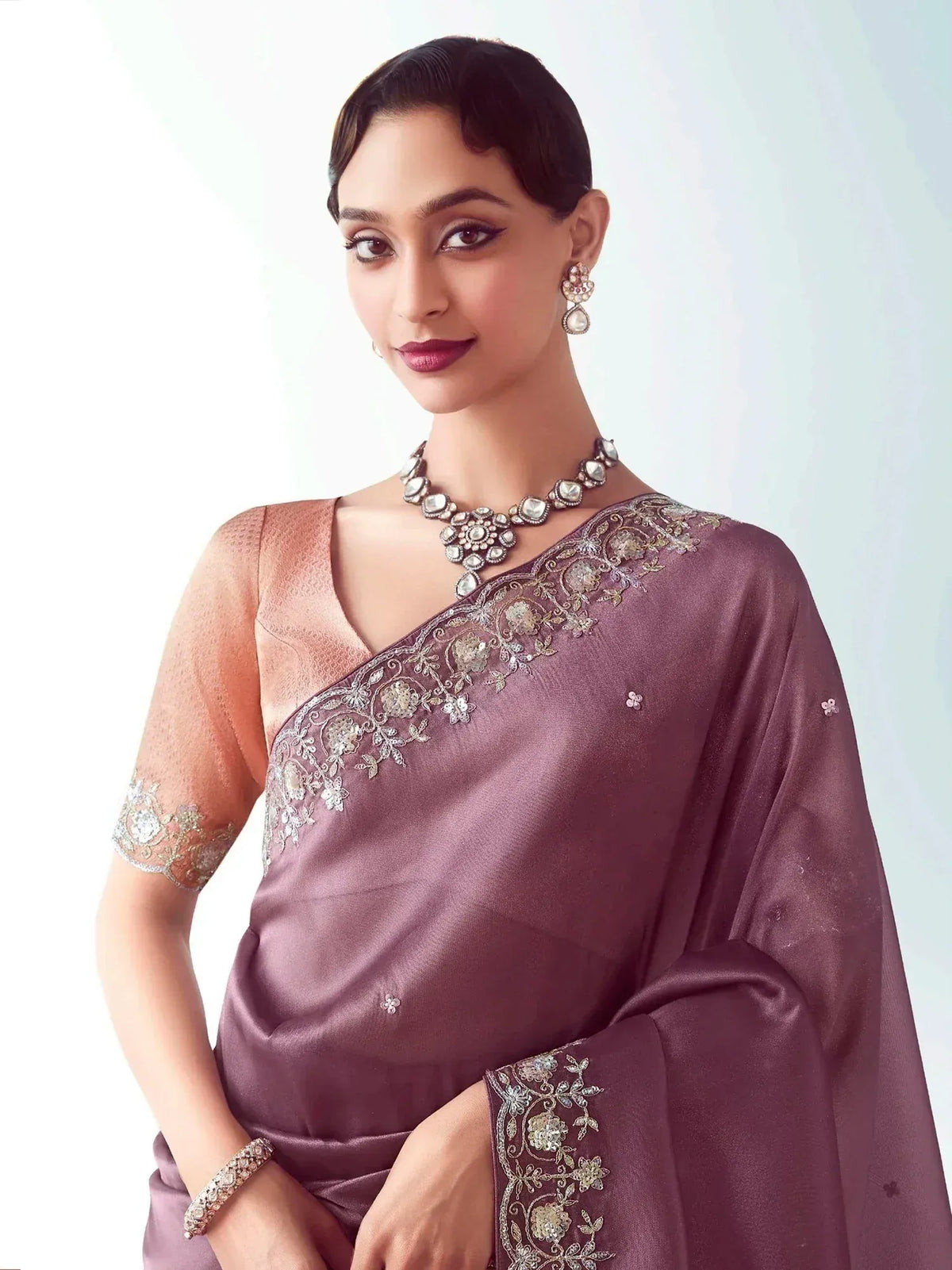 Elegant mauve saree with floral embroidery and matching blouse, styled with traditional jewelry for Indian ethnic wear.