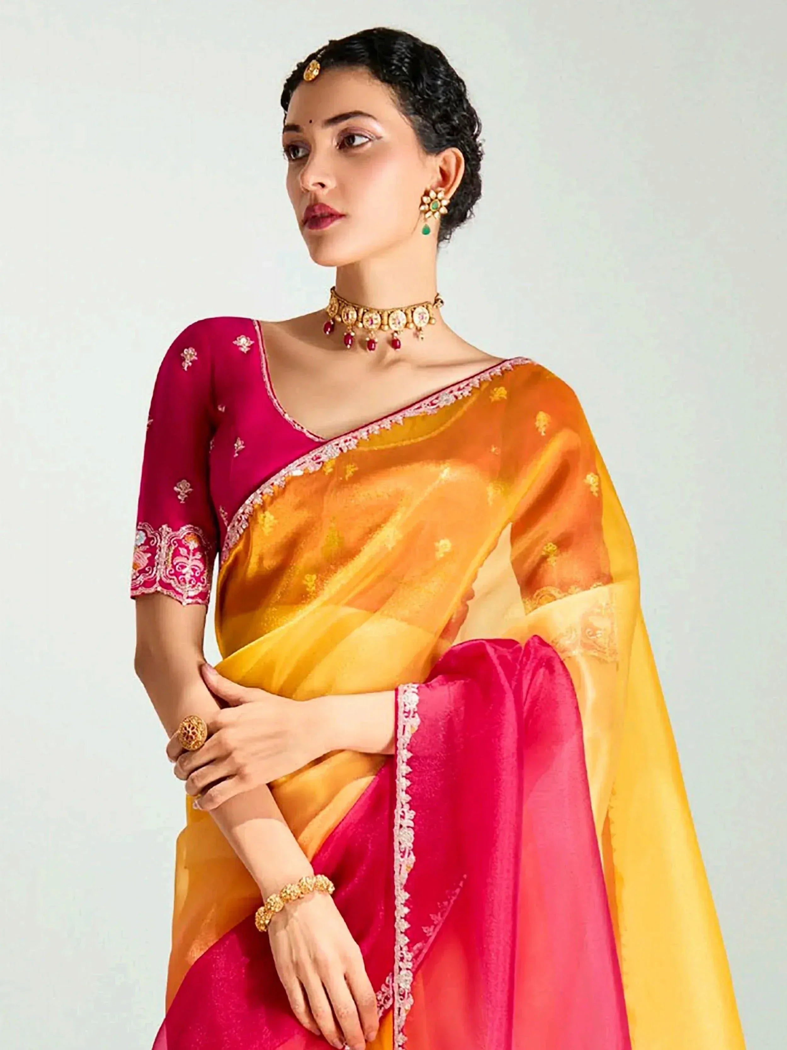 Woman in vibrant pink and yellow designer saree with embroidery, traditional Indian ethnic wear