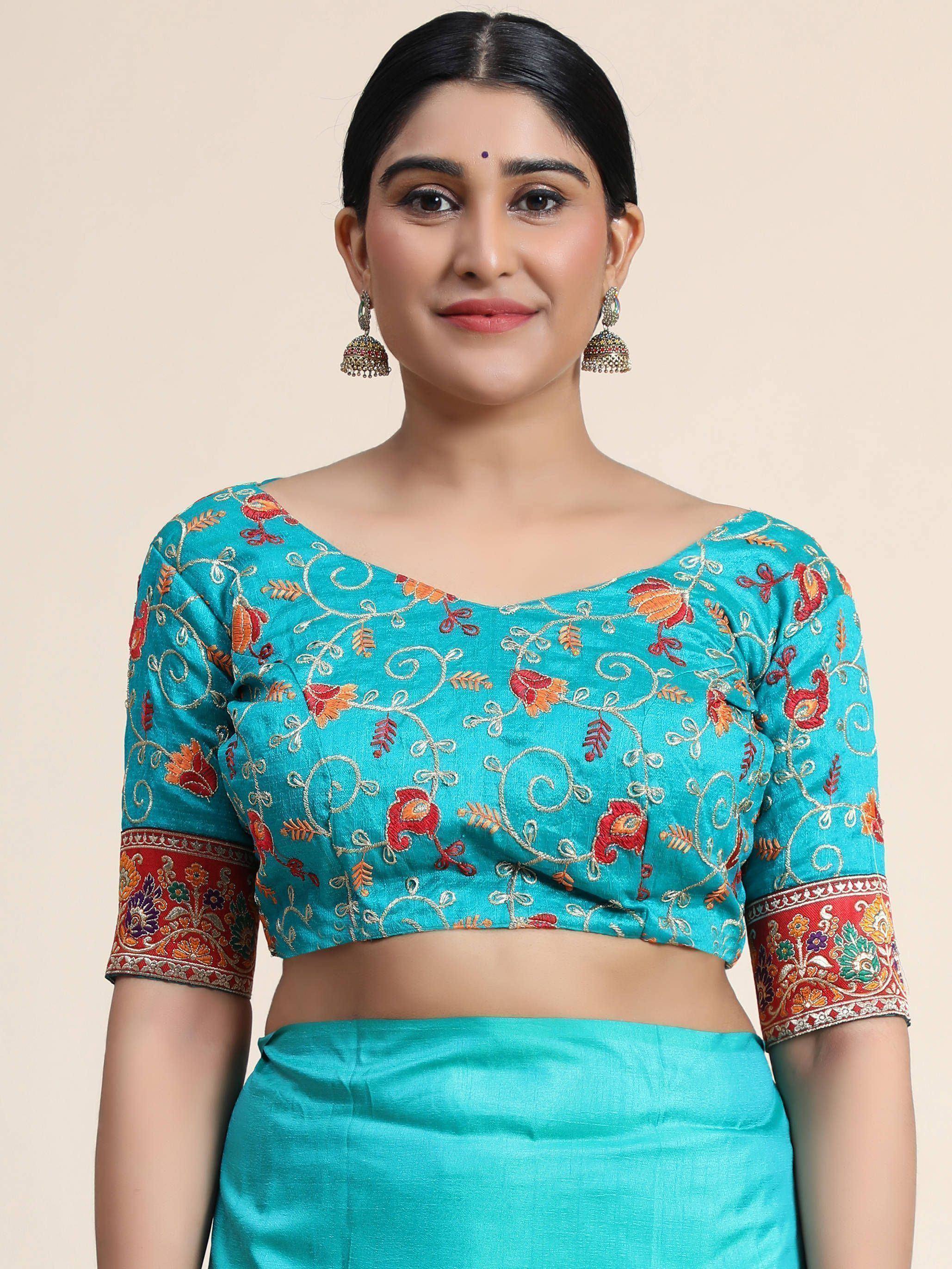 Turquoise embroidered blouse with floral motifs and red border, paired with matching skirt for Indian ethnic wear