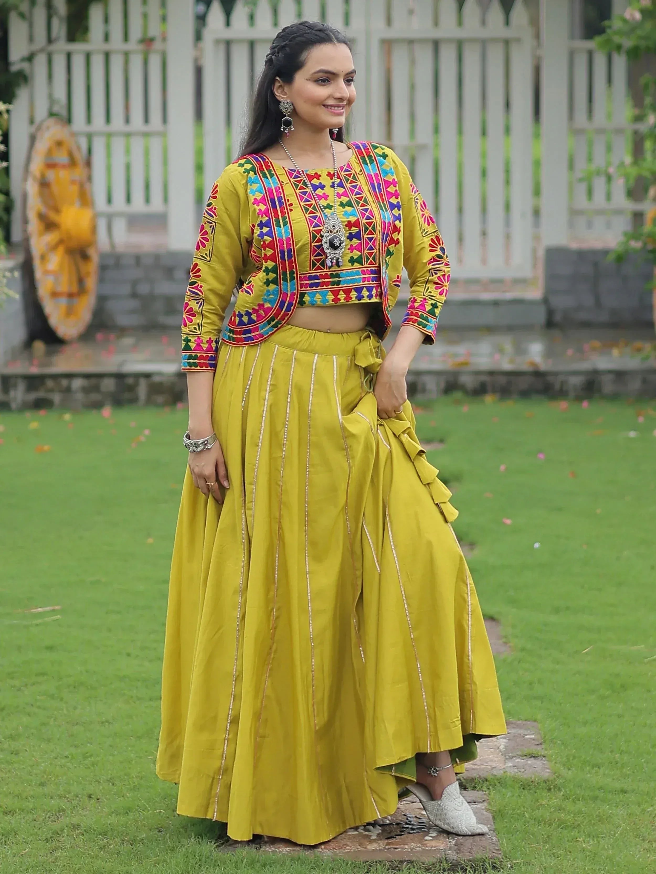 Yellow embroidered ethnic lehenga choli with colorful mirror work, perfect for Indian festivals and weddings