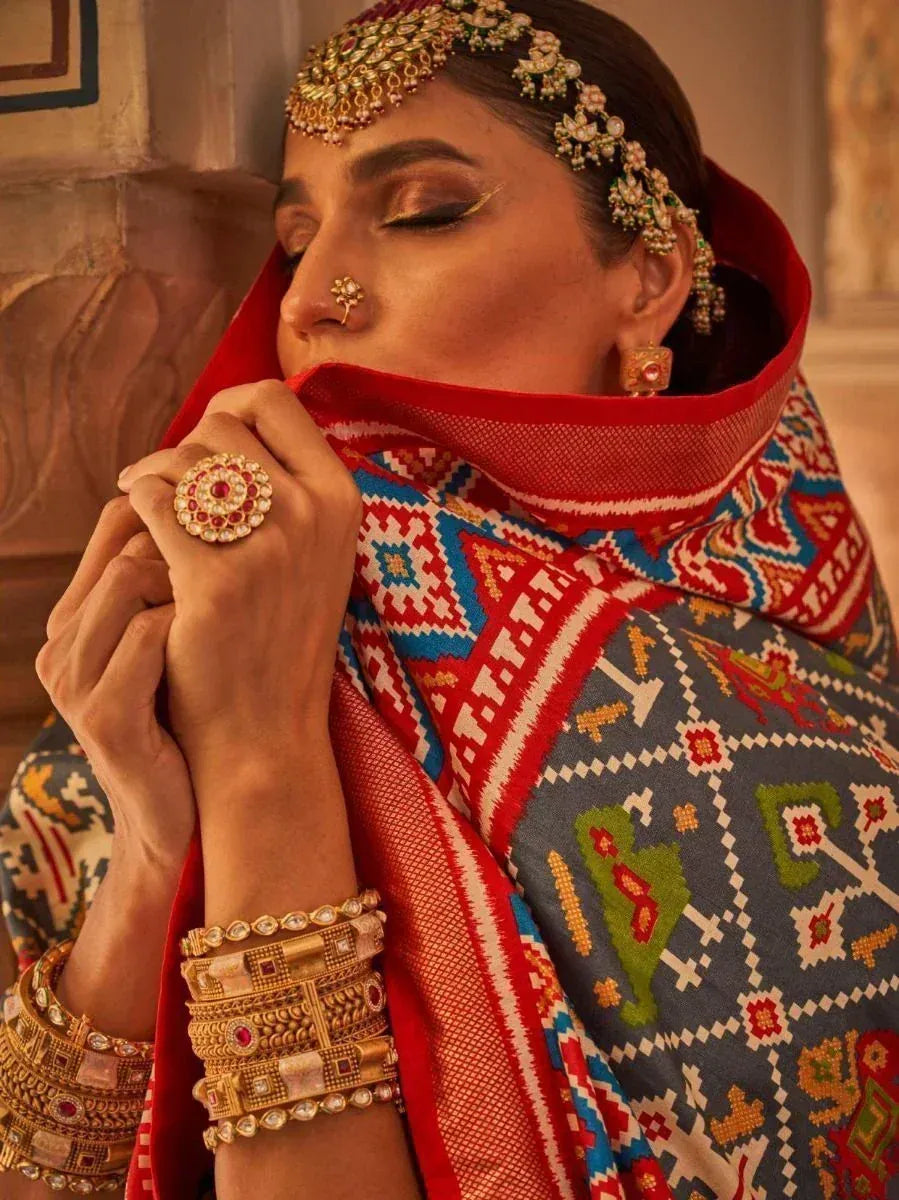 Woman in traditional Indian ethnic wear with embroidered dupatta, gold jewelry, and maang tikka