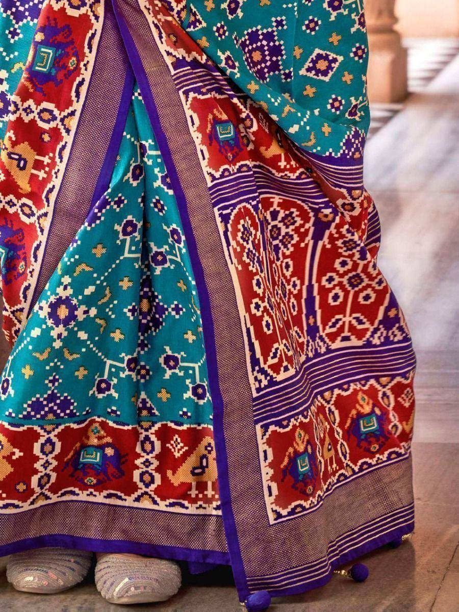 Vibrant ethnic saree with teal, red, and purple geometric patterns, perfect for Indian festive occasions