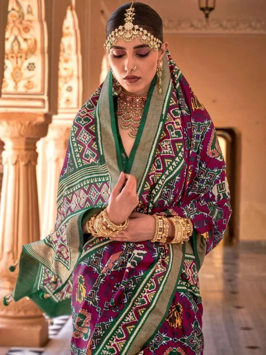 Elegant Indian woman in purple and green patterned saree with gold jewelry, traditional ethnic wear
