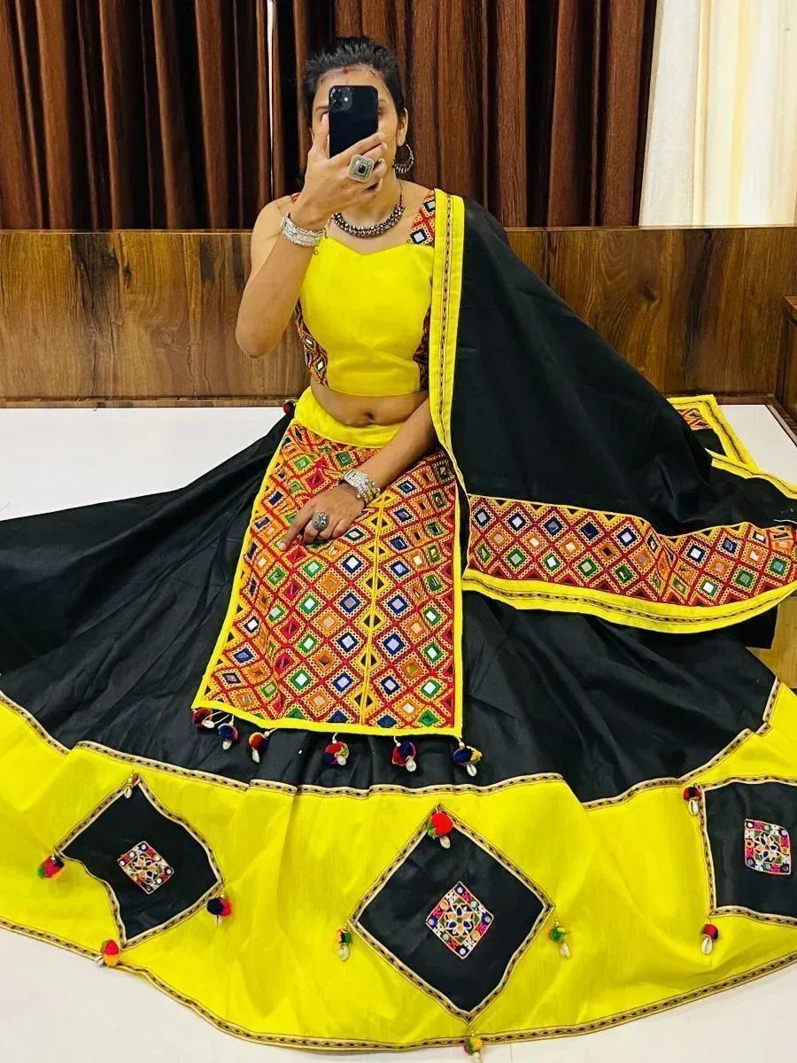 Yellow and black embroidered lehenga choli with mirror work and pom-poms, perfect for ethnic occasions