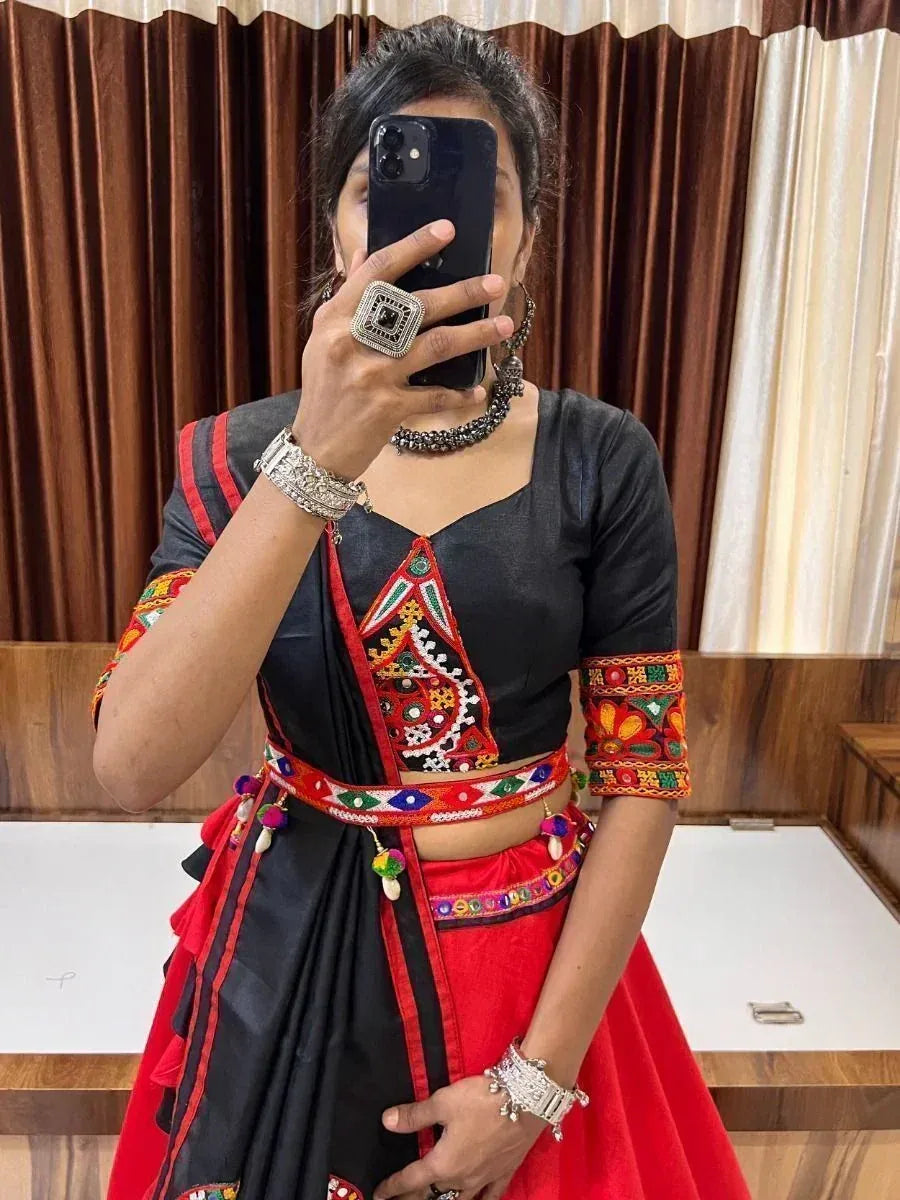 Black and red ethnic lehenga choli with colorful embroidery and mirror work, styled with traditional jewelry