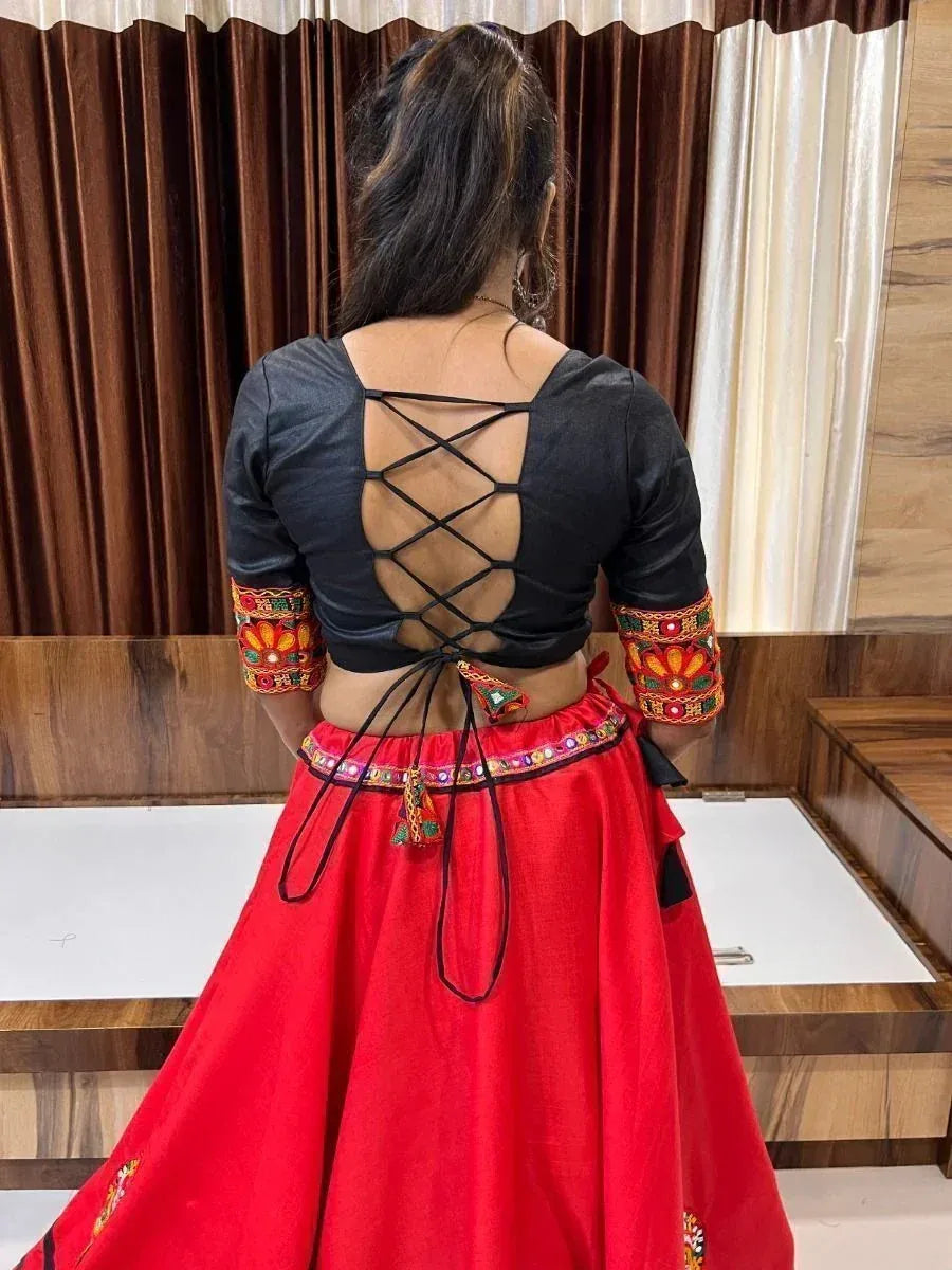 Black crisscross back blouse with embroidered sleeves paired with red ethnic skirt, perfect for Indian festive wear.
