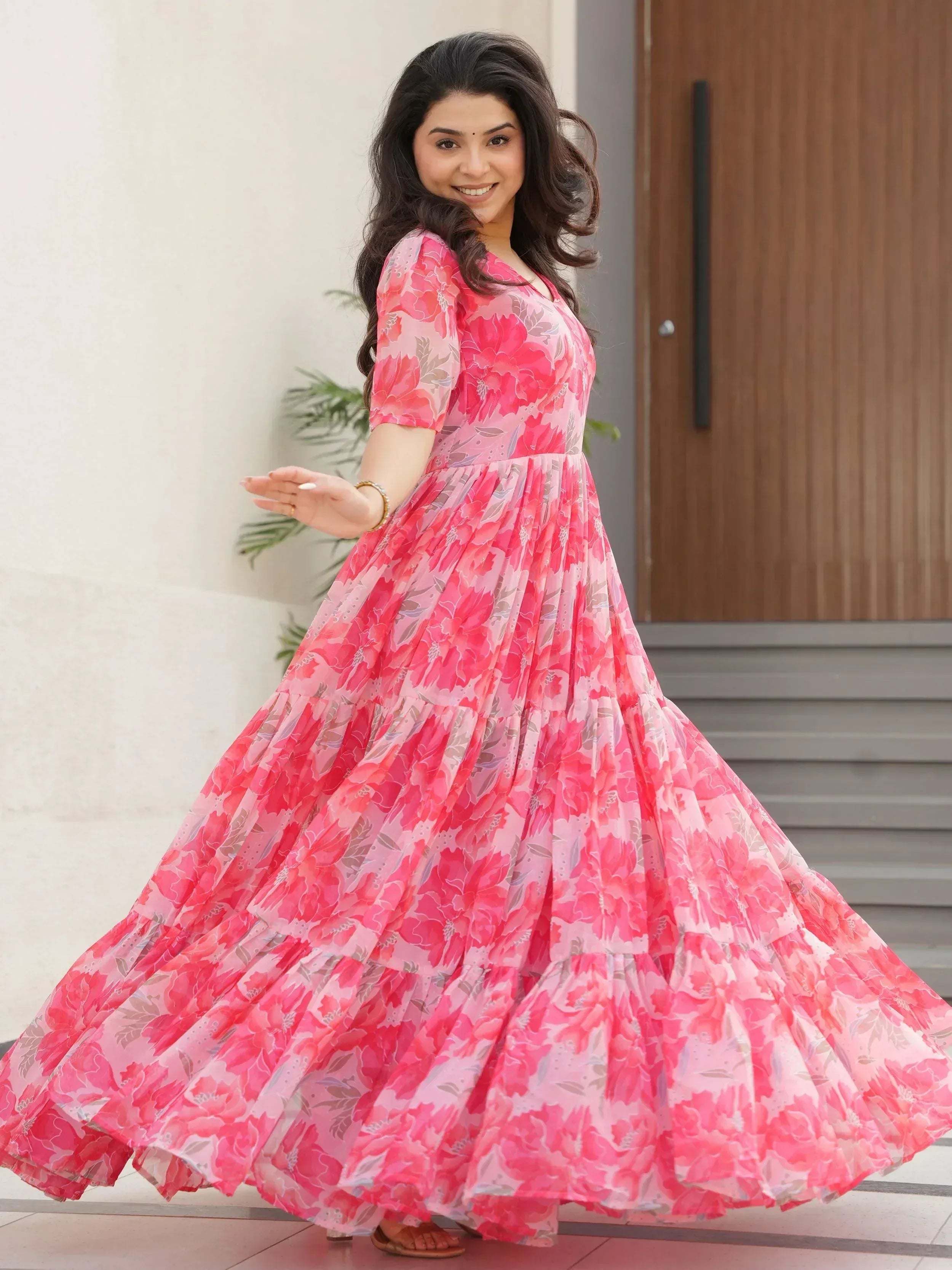 Woman in pink floral ethnic gown with flared skirt, perfect for Indian occasions