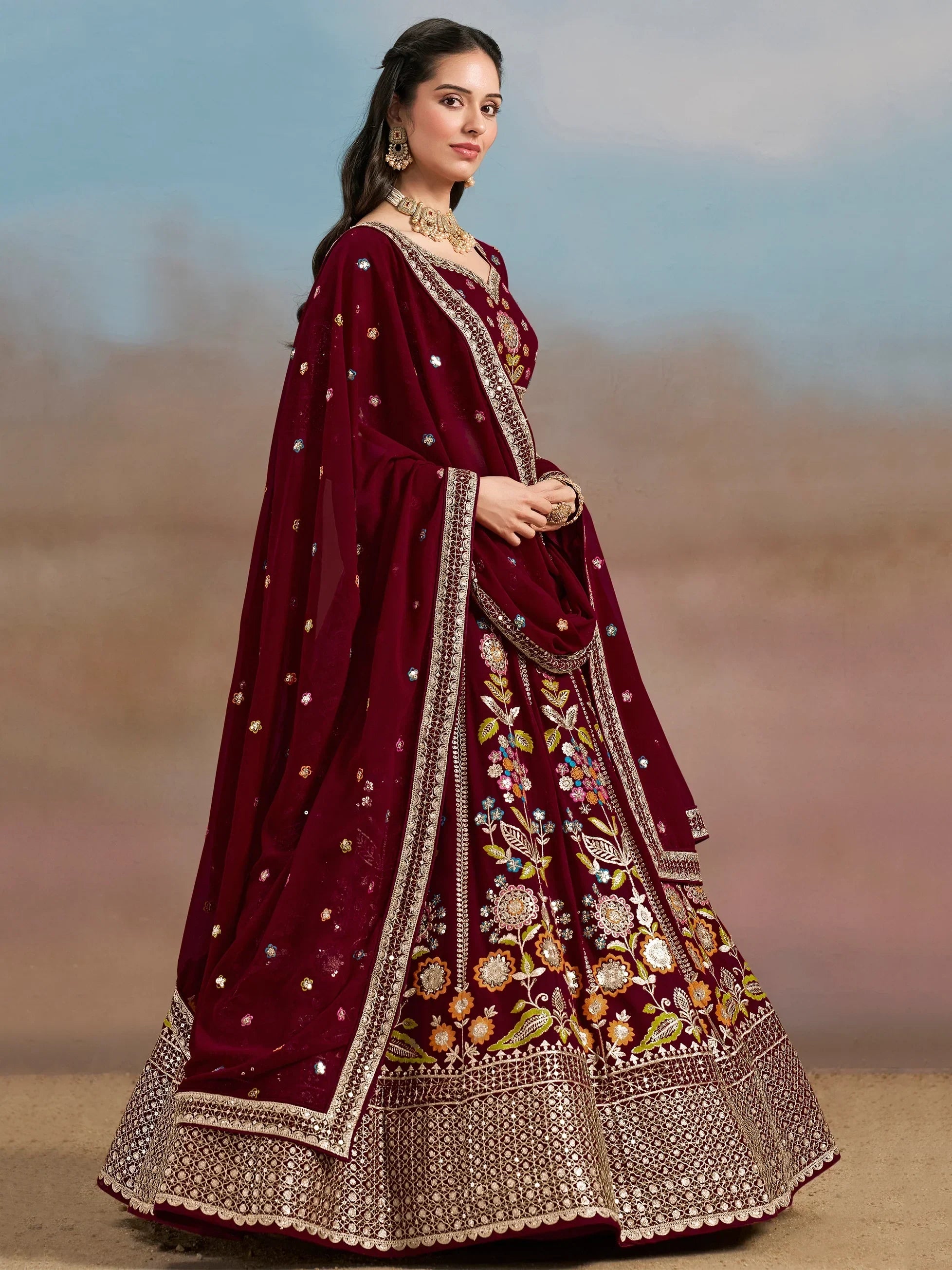 Maroon embroidered lehenga choli with floral motifs and gold detailing, perfect for Indian ethnic wear occasions.
