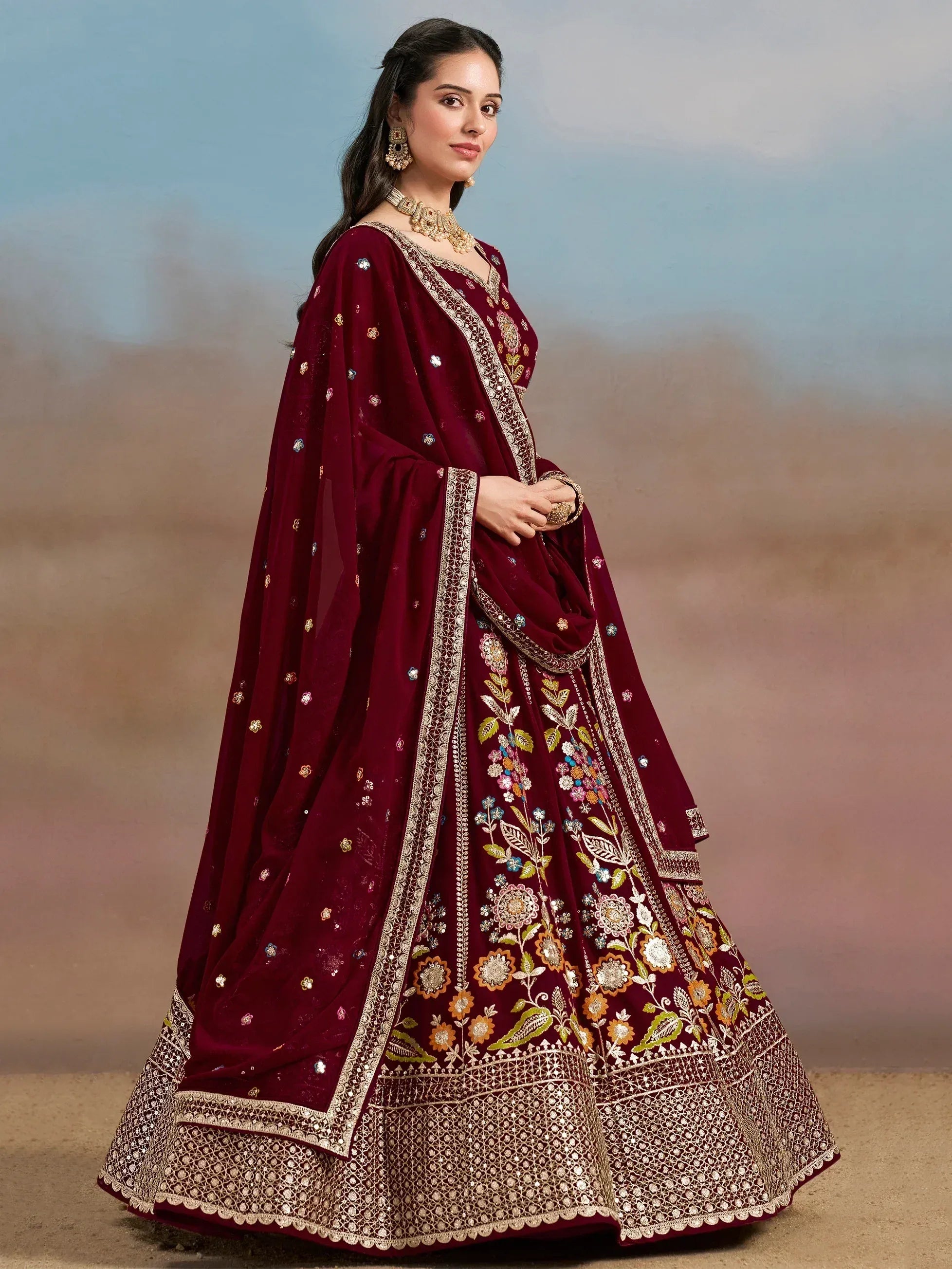 Maroon embroidered lehenga choli with floral motifs and gold detailing, perfect for Indian ethnic wear occasions.