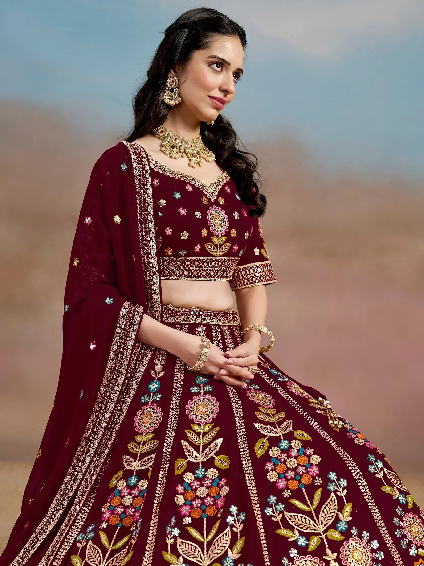 Maroon designer lehenga choli with floral embroidery and gold detailing, perfect for Indian ethnic wear occasions.