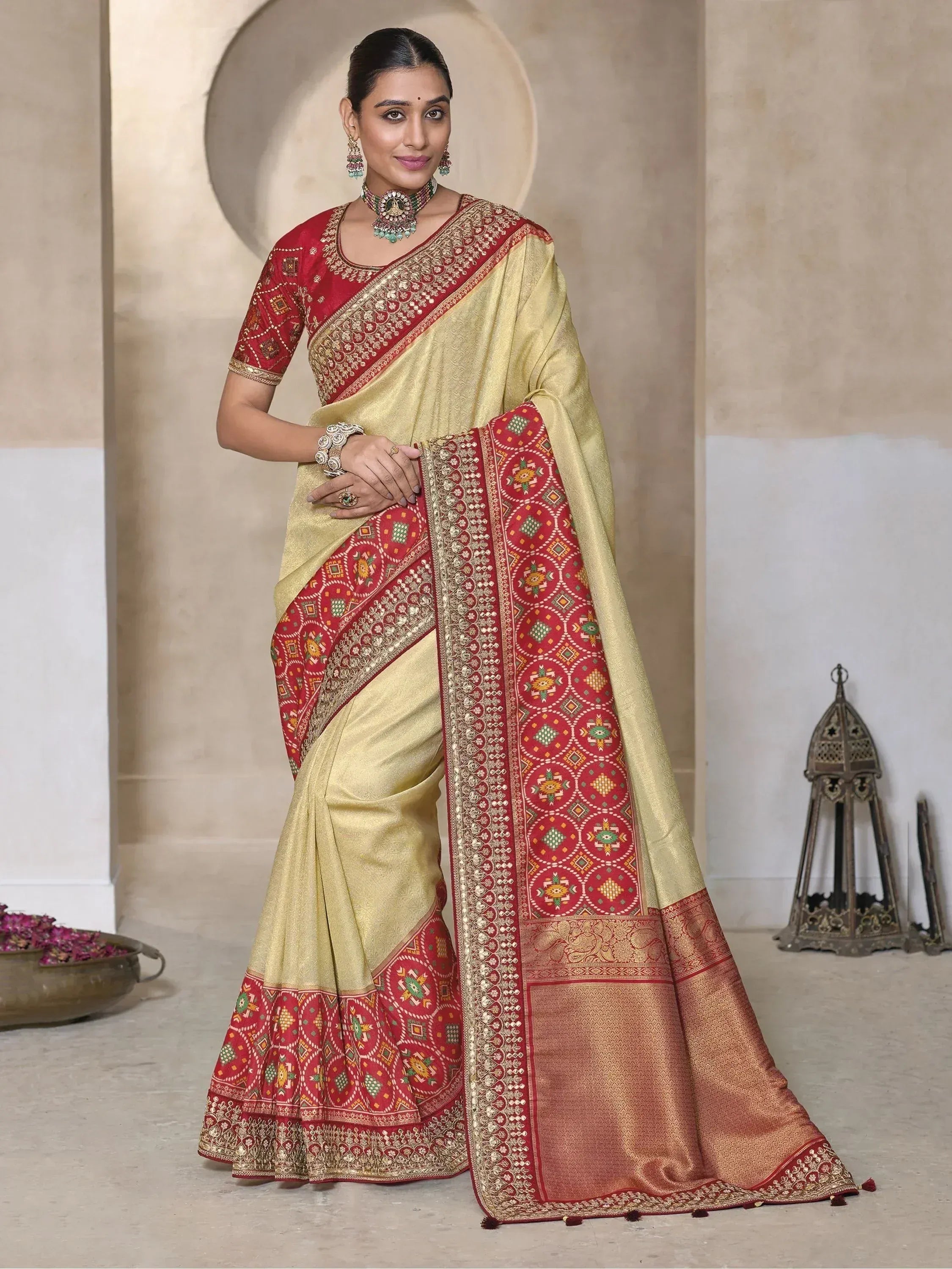 Elegant gold and red designer saree with intricate embroidery and traditional Indian patterns