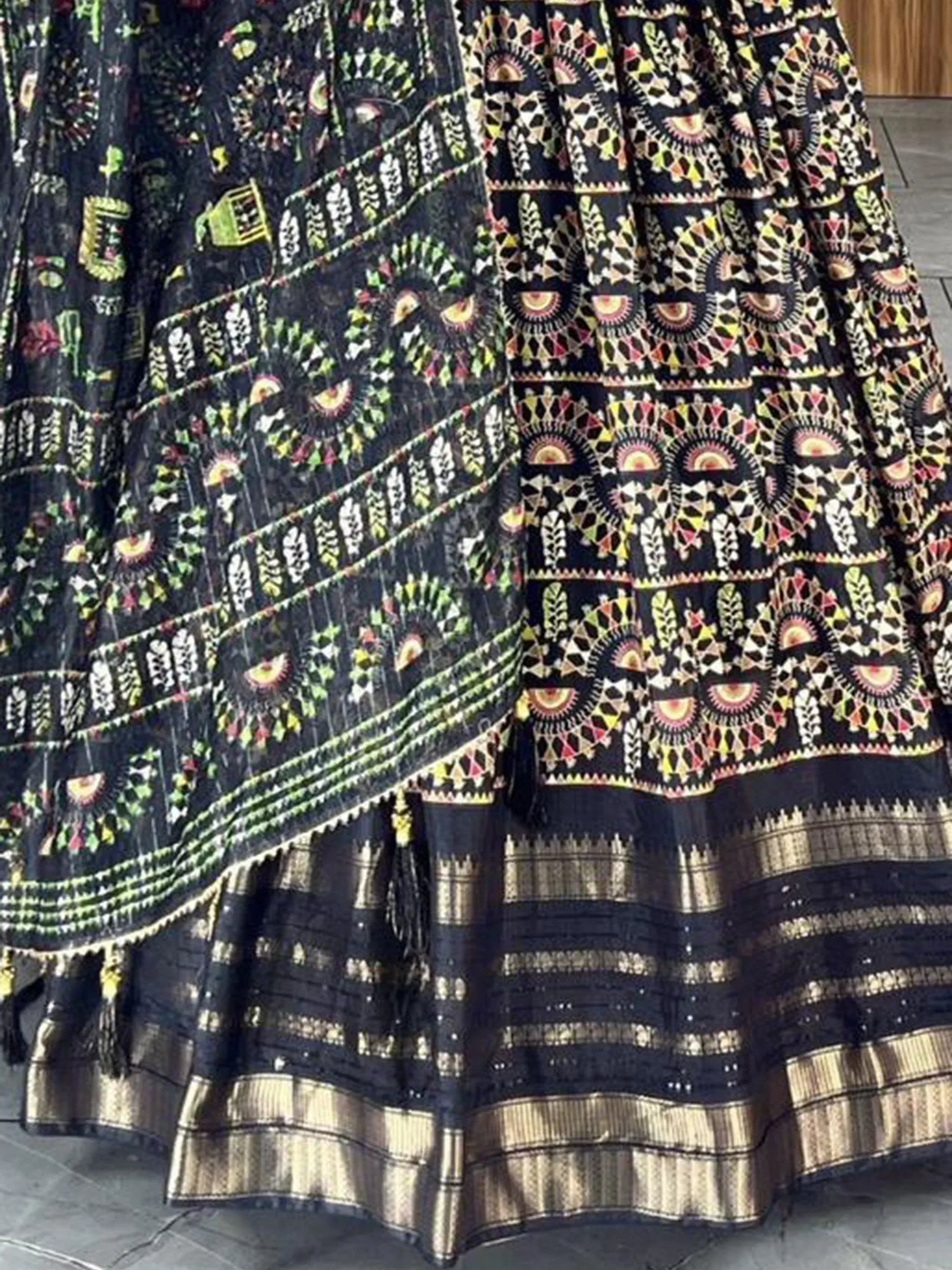 Black ethnic lehenga with vibrant geometric embroidery and gold border, ideal for Indian festive wear