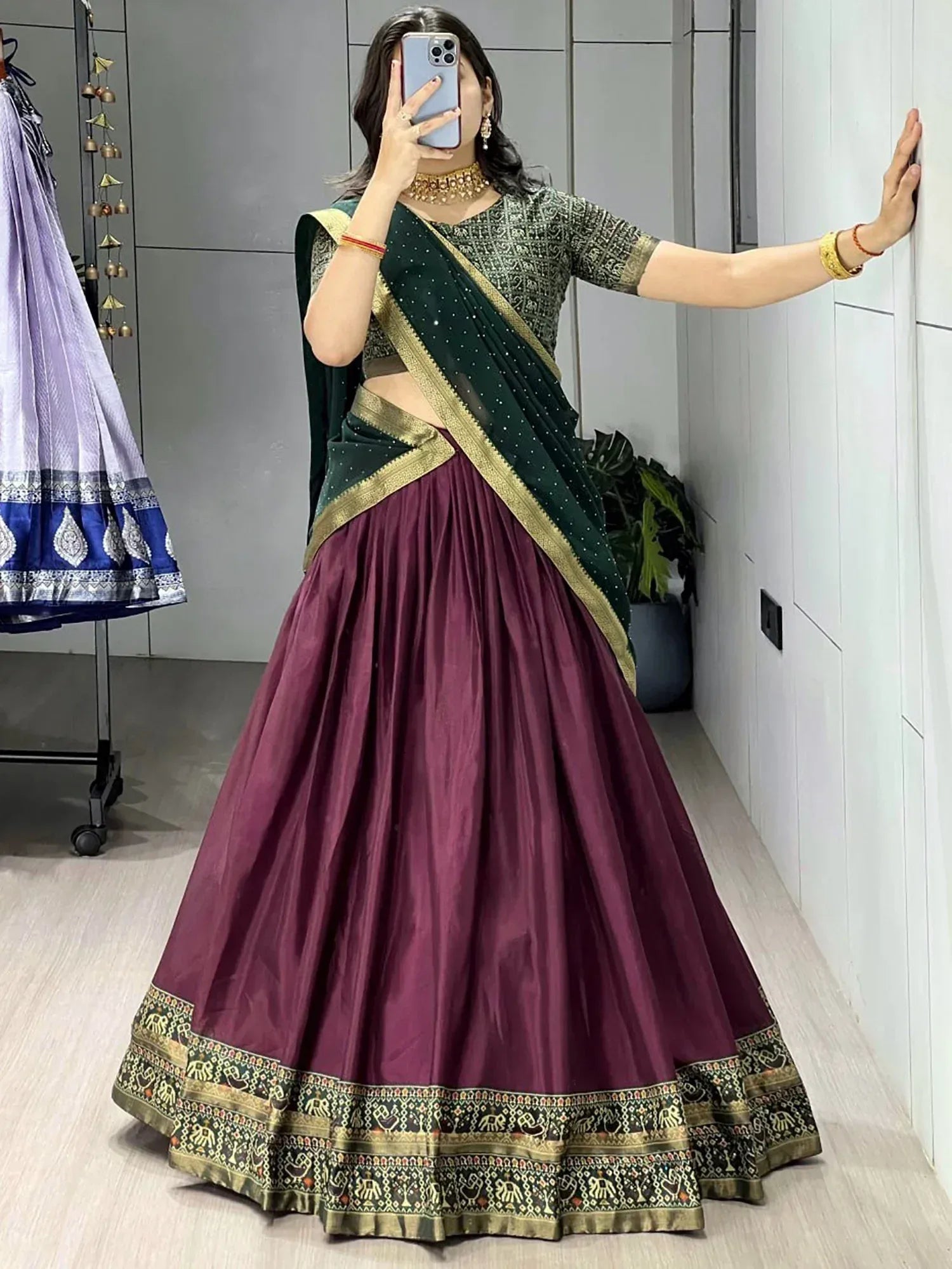 Woman in maroon lehenga choli with green dupatta, gold embroidery, ethnic Indian wear