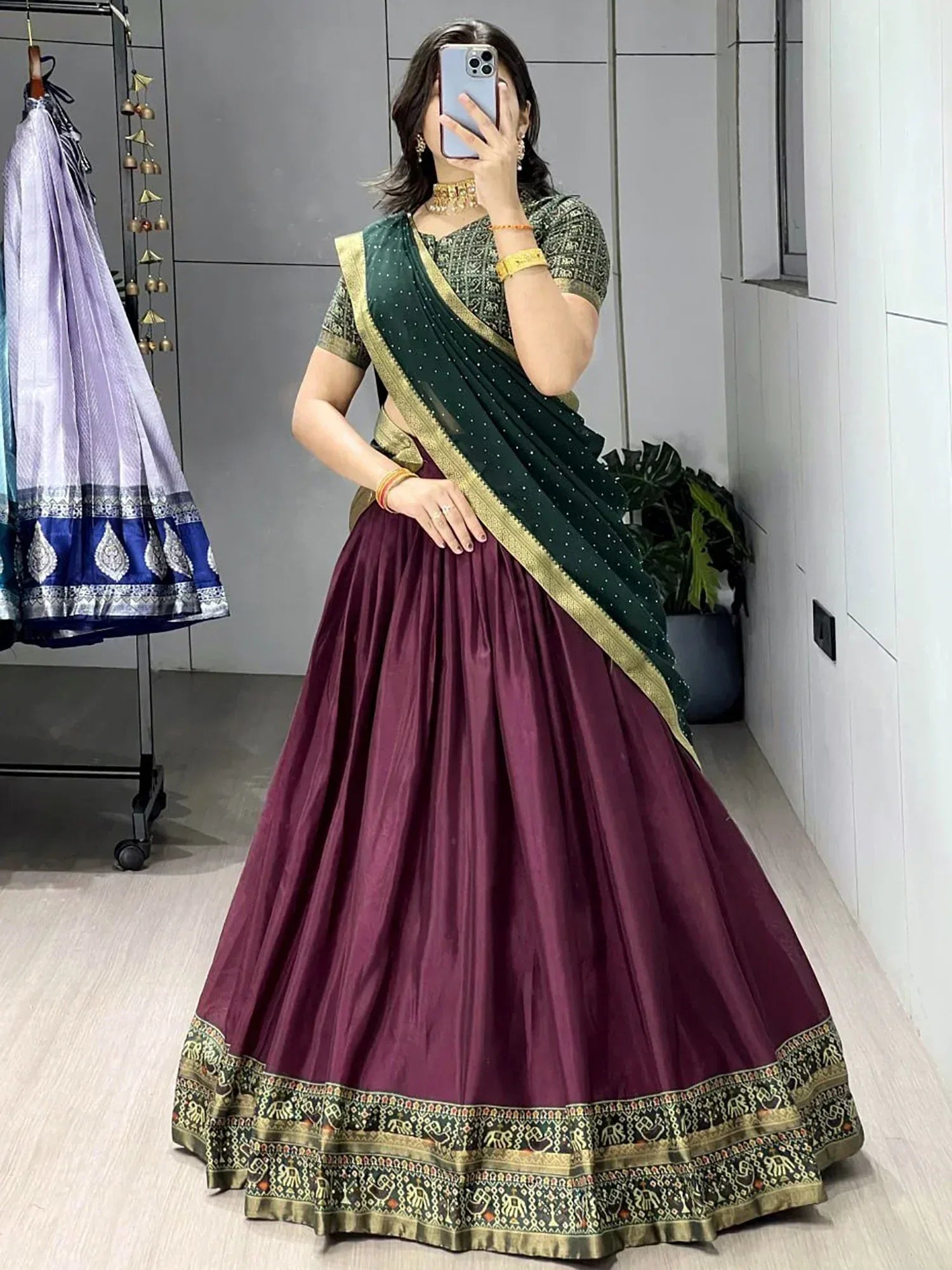 Woman in maroon lehenga choli with green dupatta, ethnic Indian wear for festive occasions