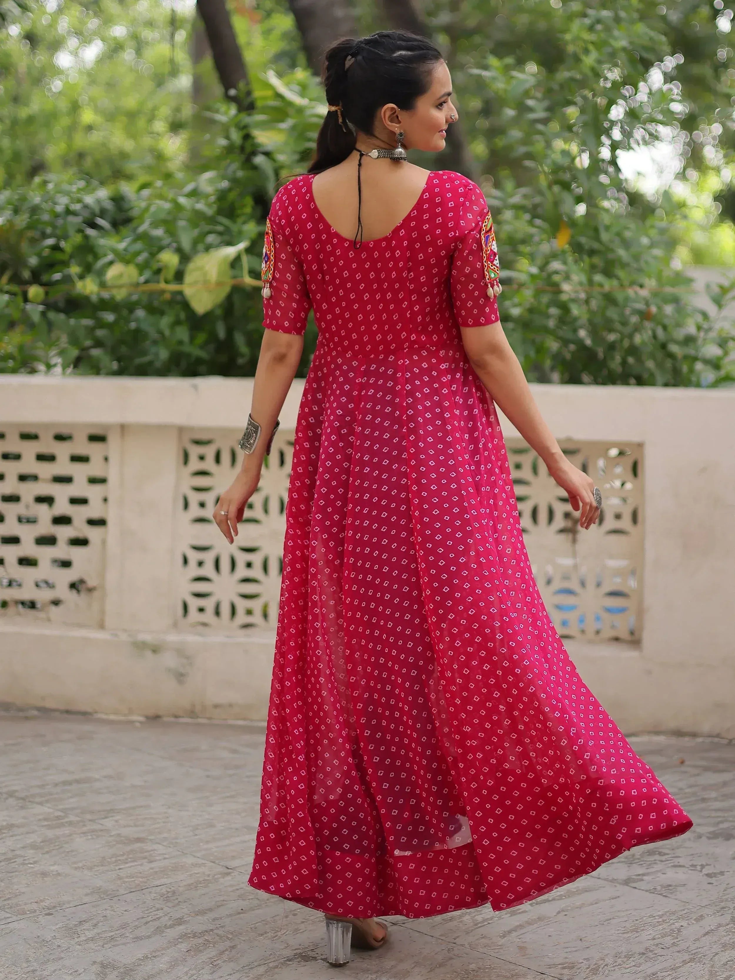 Woman in red ethnic gown with geometric print and embroidered sleeves, perfect for Indian occasions