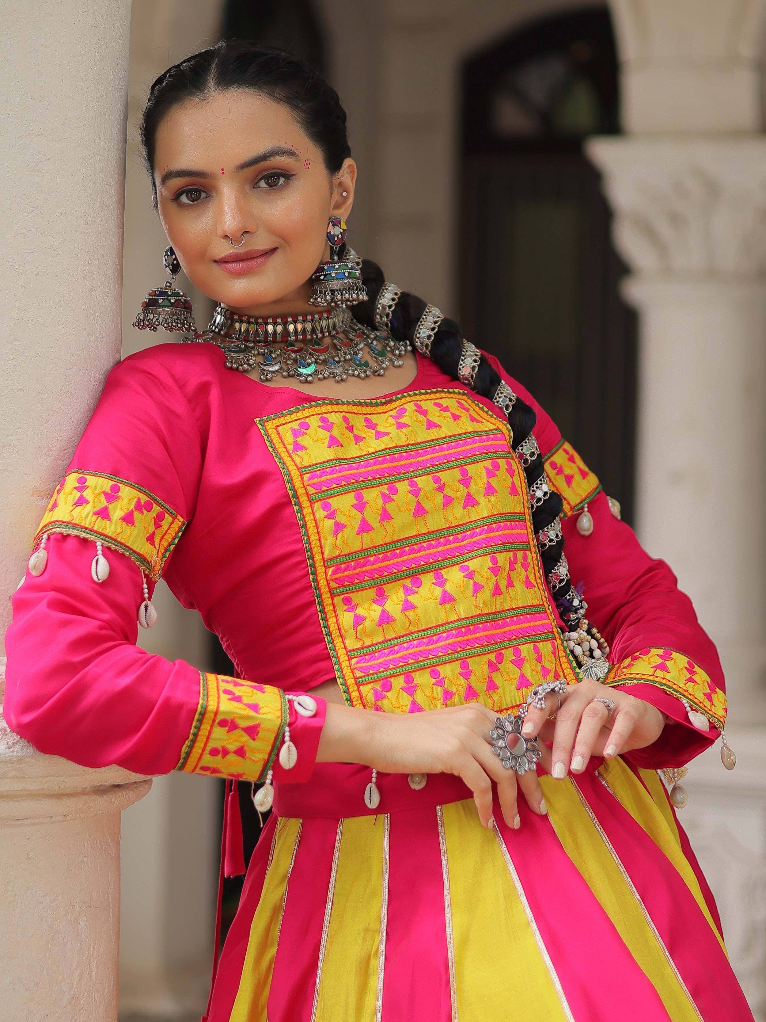 Vibrant pink and yellow ethnic wear with intricate embroidery and traditional jewelry