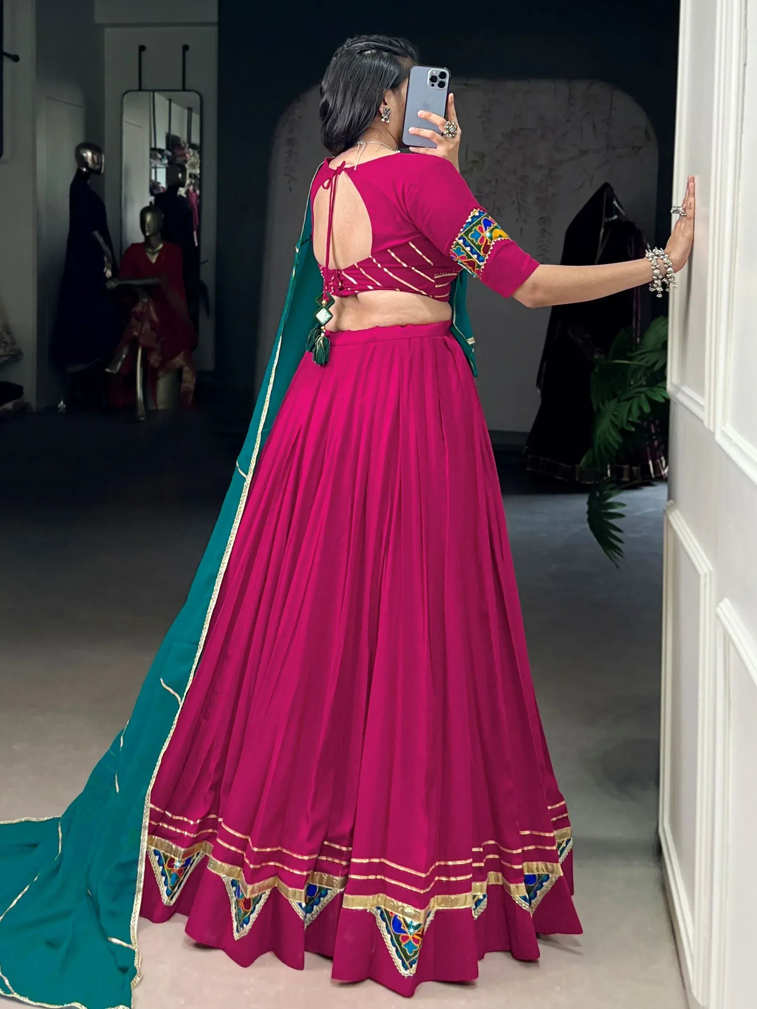 Fuchsia lehenga choli with green dupatta, backless blouse, and embroidered detailing for Indian ethnic wear