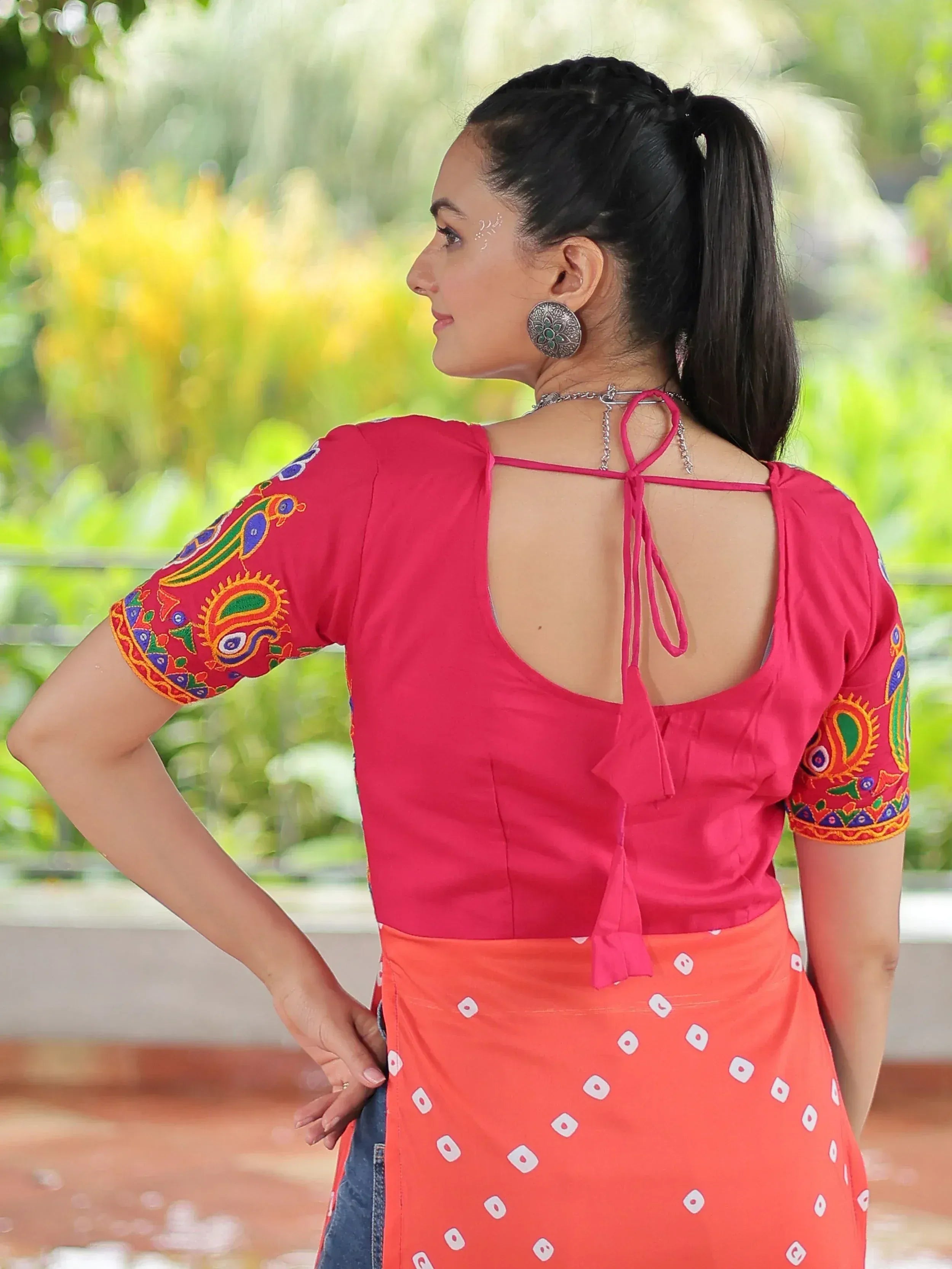Pink embroidered blouse with open back tie, paired with orange bandhani skirt, ethnic Indian wear