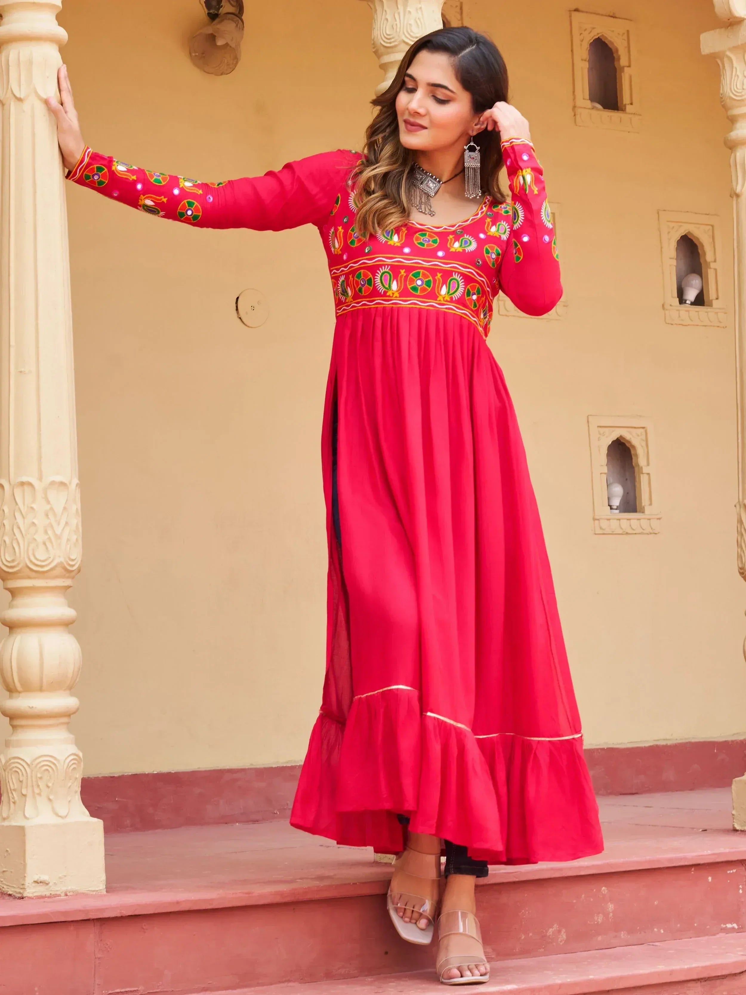 Vibrant red ethnic gown with colorful embroidery, perfect for Indian festive occasions and traditional wear.